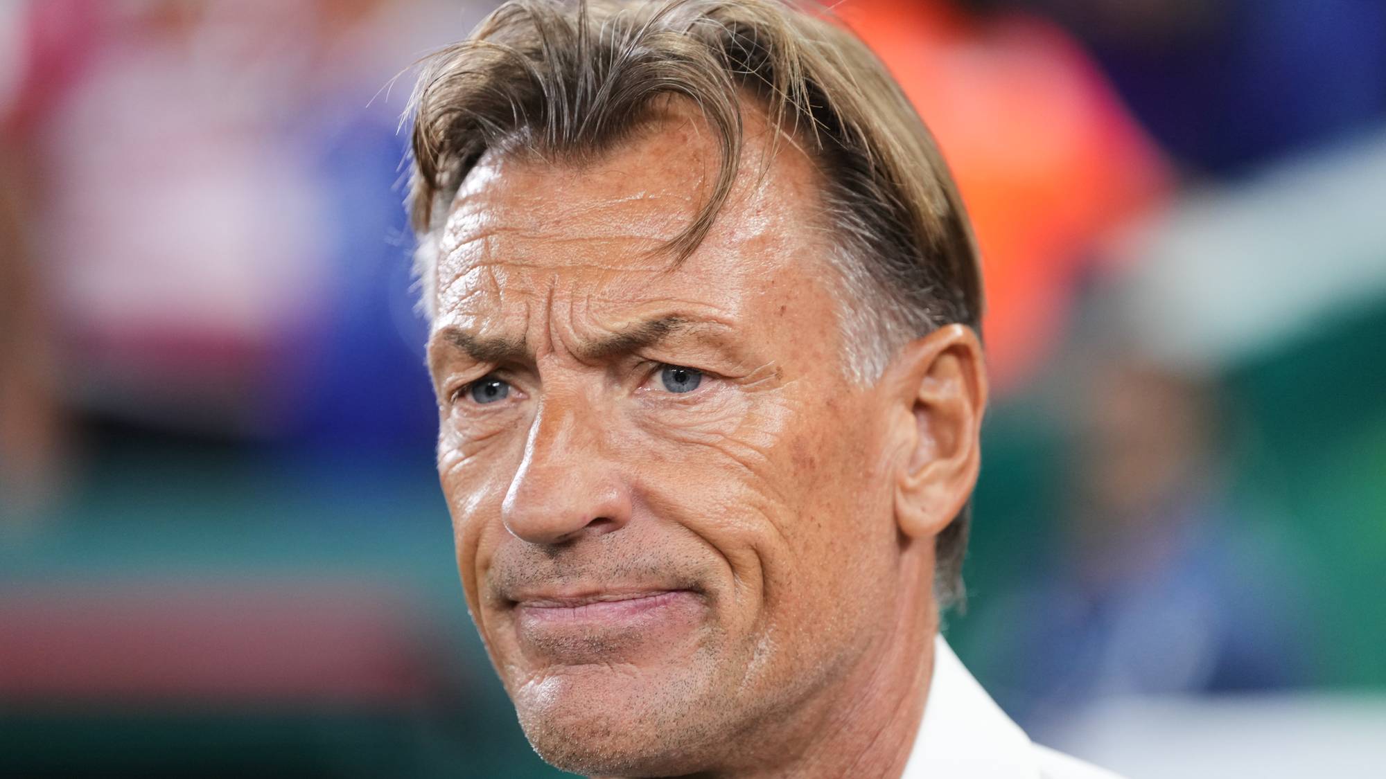 En mann med brunt hår og blå øyne sees fra brystet og opp. Han har på seg en hvit skjorte. Bakgrunnen er ute av fokus og viser fargede former. (Bildebeskrivelsen er laget av en KI-tjeneste)