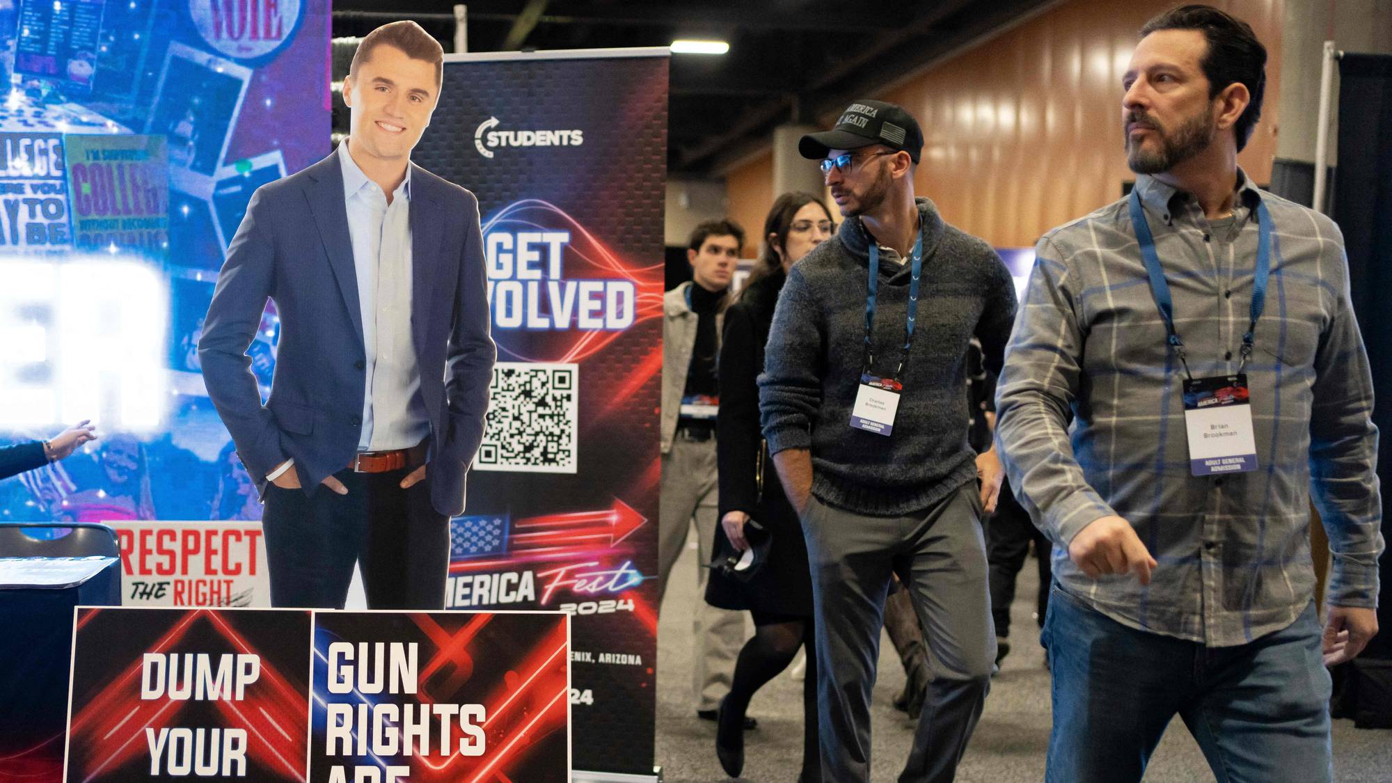 Folk går forbi en pappfigur av Charlie Kirk