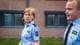 Jenny Dahl Bakken / NRK Bildet viser to fengselsbetjenter som går forbi et murbygg bak et gittergjerde