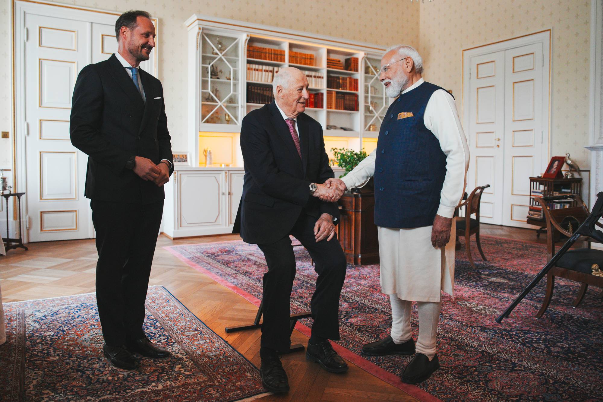 Prins Haakon, Kong Harald og Indias statsminister Narendra Modi møtes. De to statslederne håndhilser i en stue. 