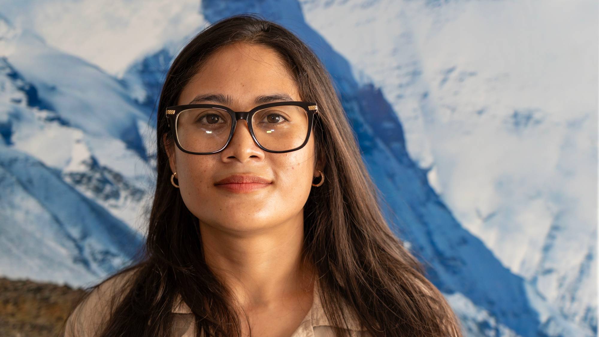 Kvinnelig nepalsk forsker ved datamaskin og ved bilde av Mt. Everest