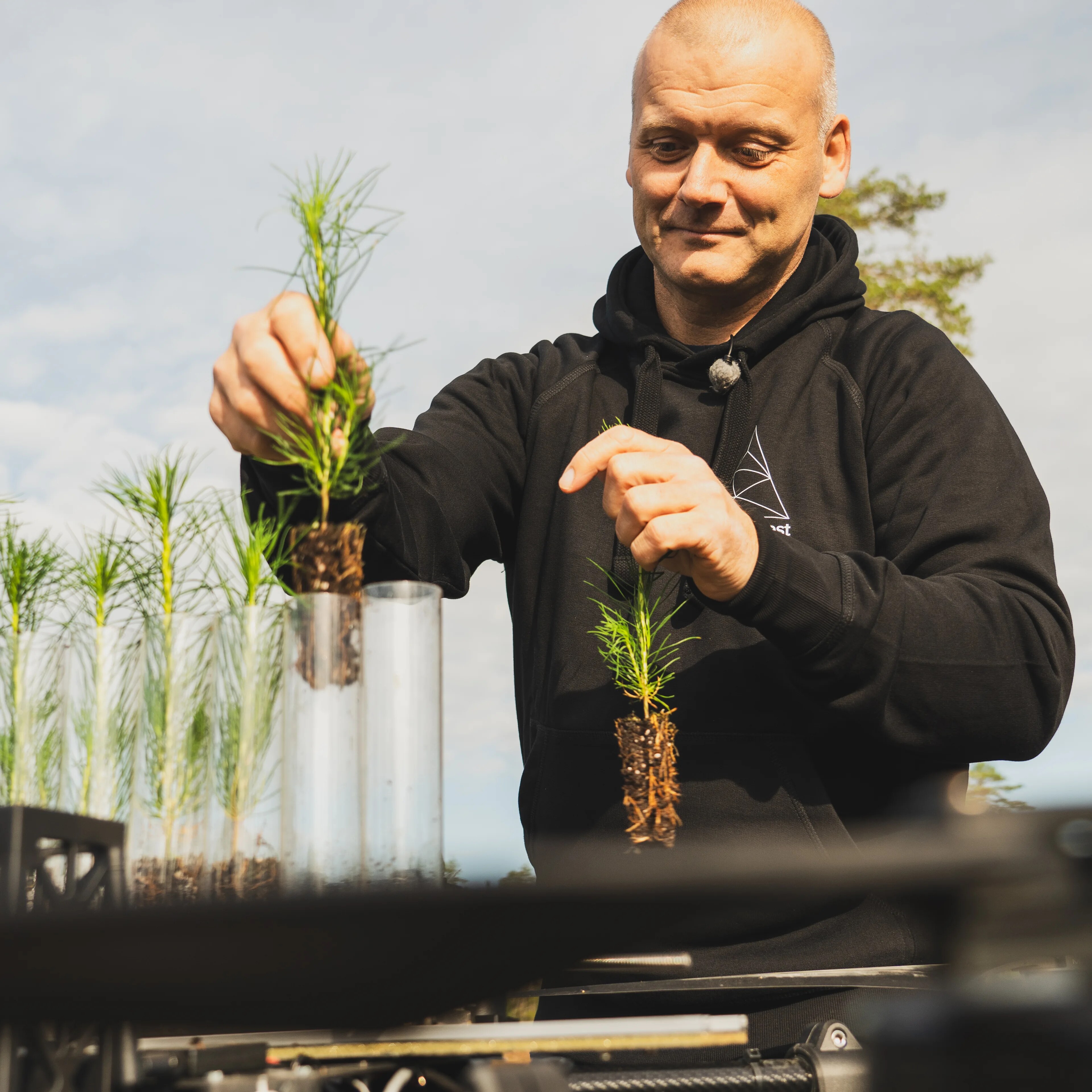 En mann putter skogplanter i en drone