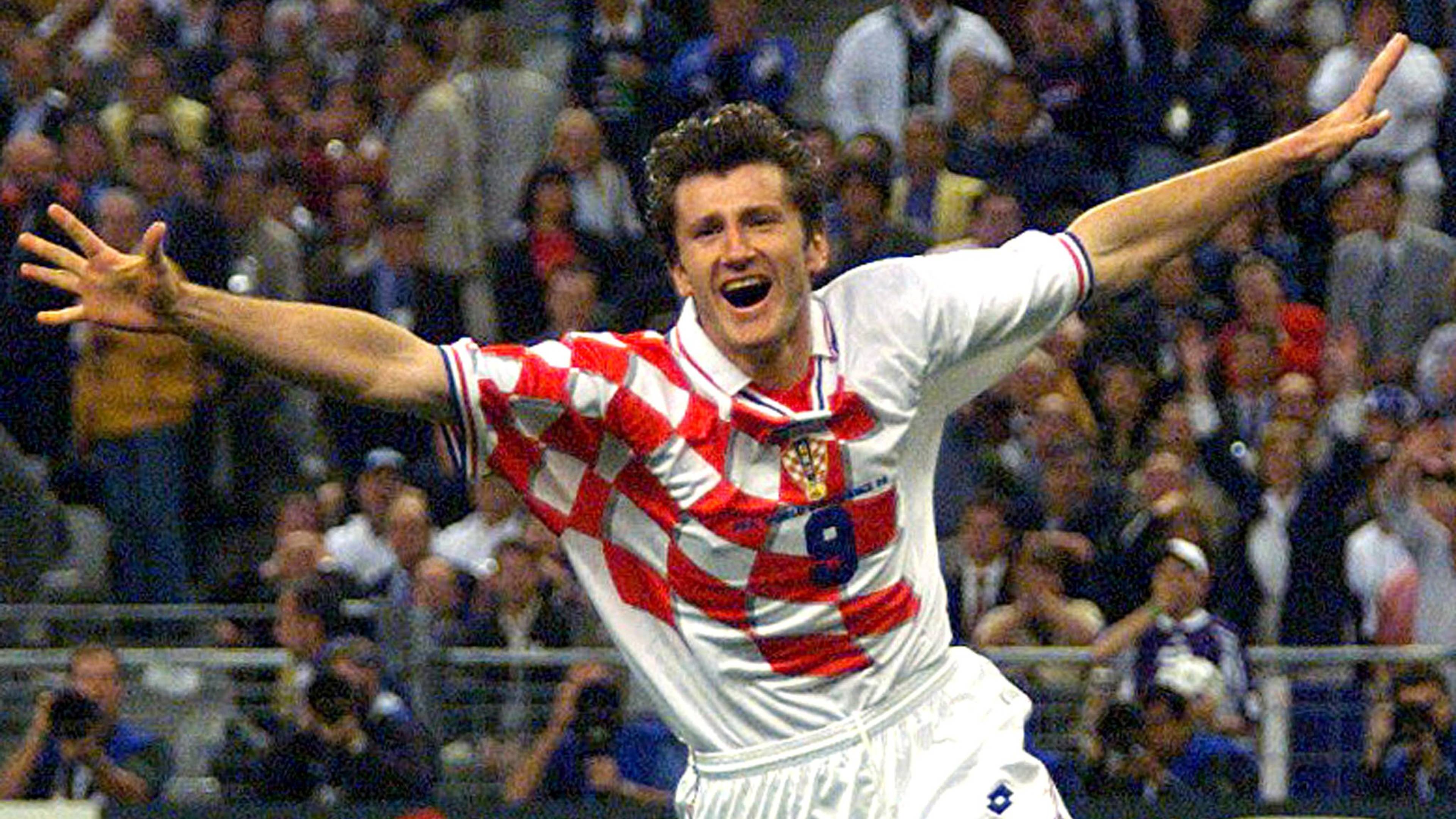 Davor Šuker jubler med utstrakte armer i Kroatias landslagsdrakt foran publikum. (Bildebeskrivelsen er laget av en KI-tjeneste)