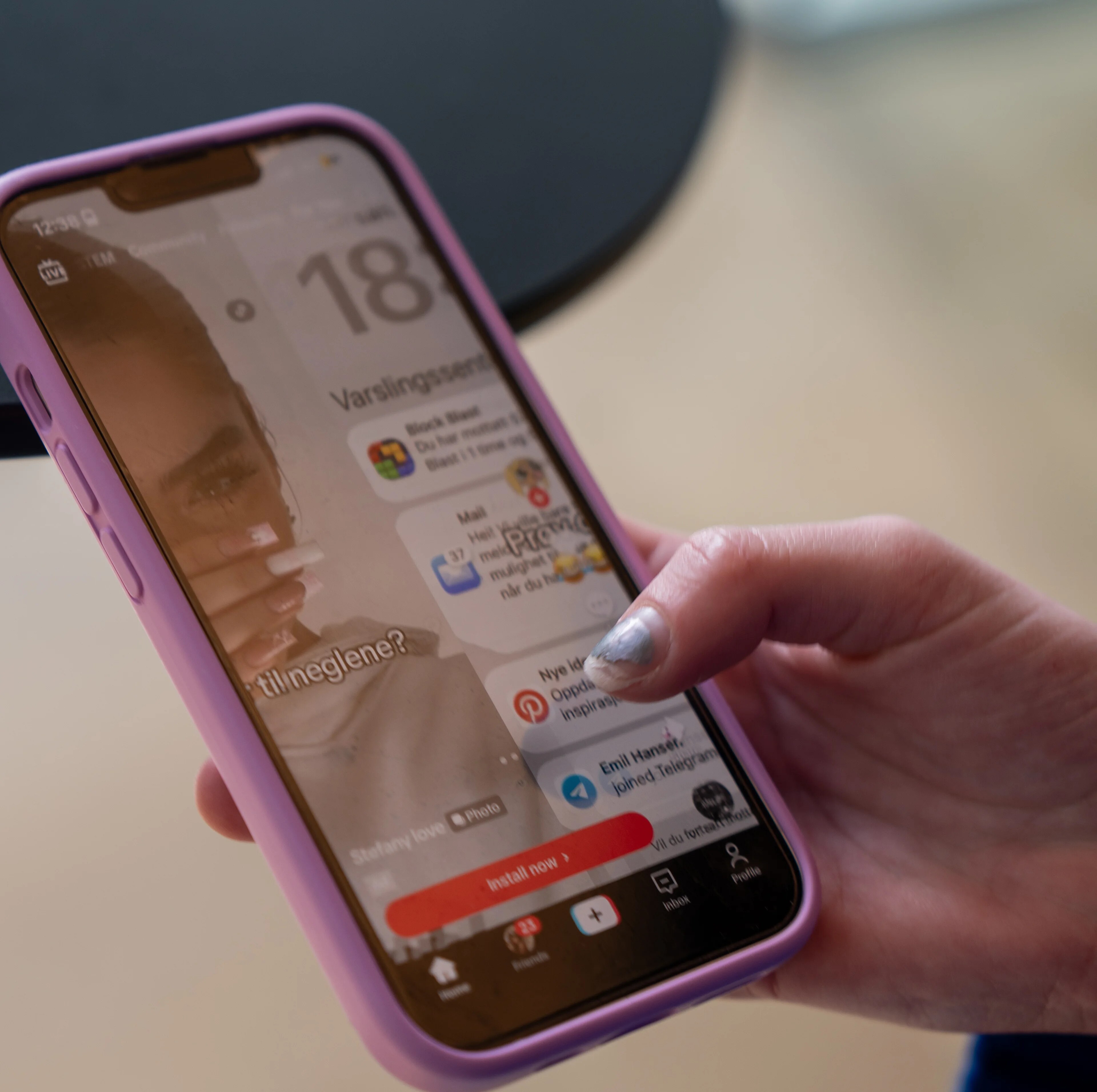 Person holder en smarttelefon med et varslingssenter synlig på skjermen. (Bildebeskrivelsen er laget av en KI-tjeneste)