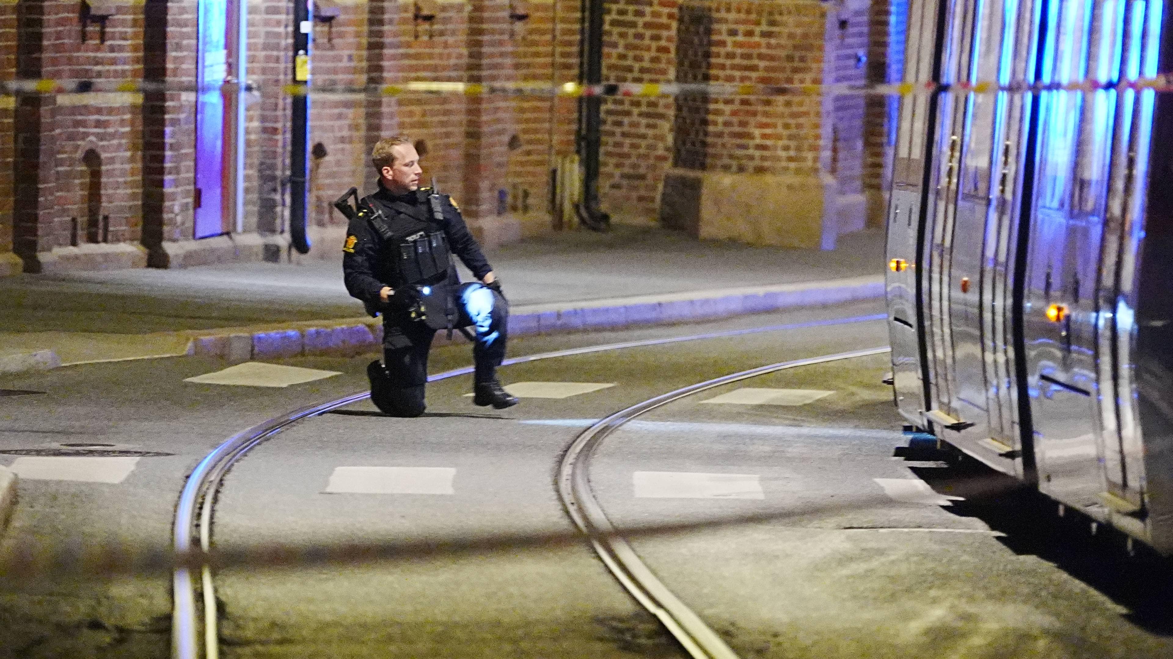 En ansatt i politiet står på kne ved det avsperrede området i Pilestredet