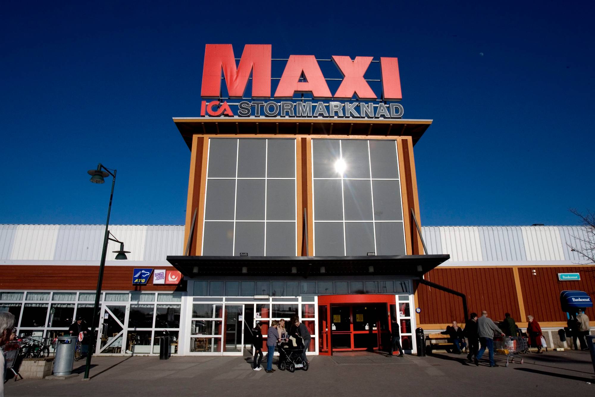 Inngangspartiet til en Ica Maxi Stormarknad-butikk med kunder på utsiden. (Bildebeskrivelsen er laget av en KI-tjeneste)