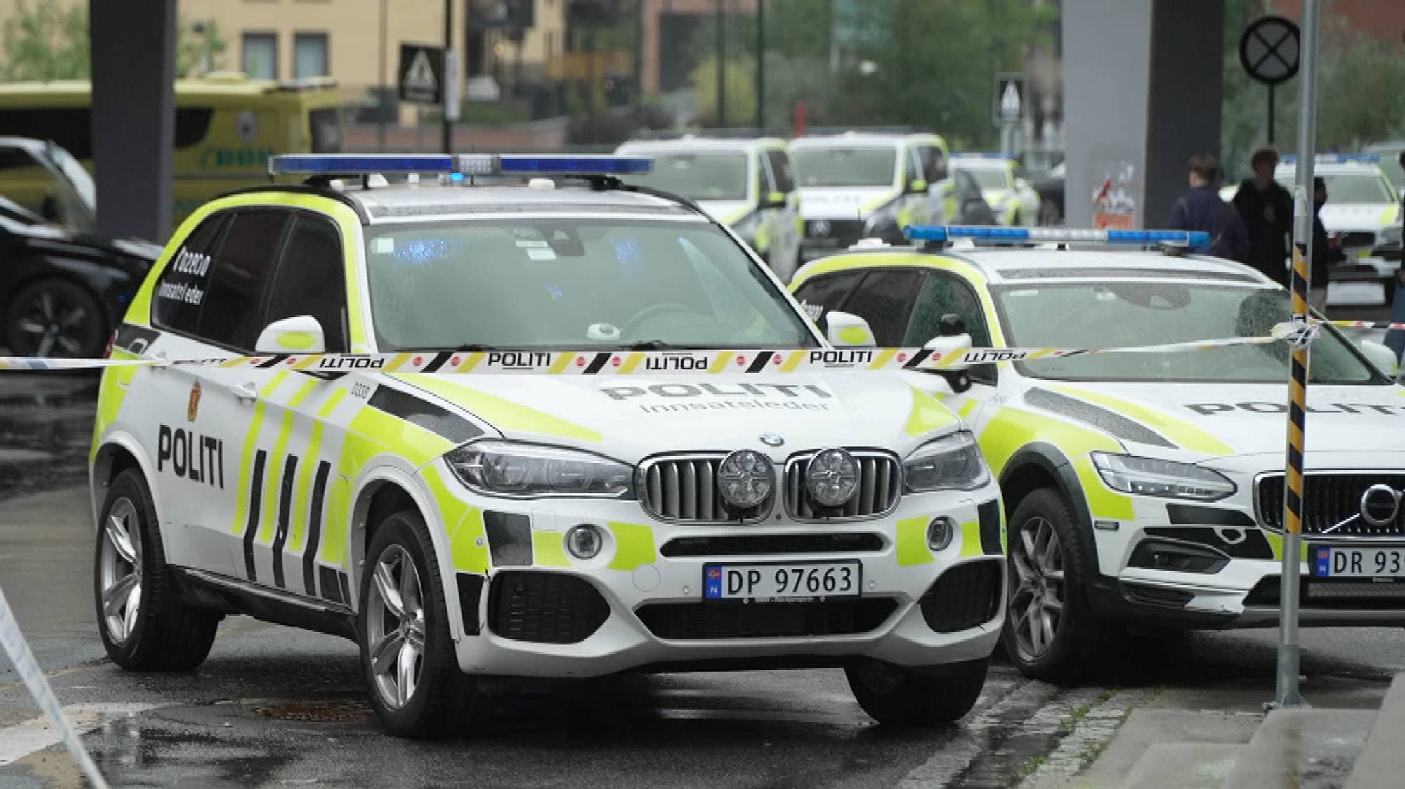 Politibiler på et avsperret område ved en parkeringsplass. (Bildebeskrivelsen er laget av en KI-tjeneste)