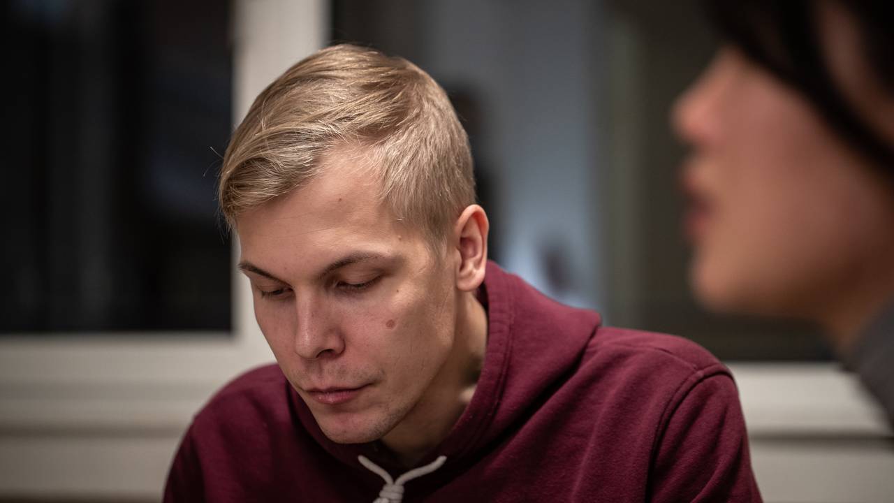 William Korneliussen ser ned, sitter ved Tram i sofaen og spiser pizza.