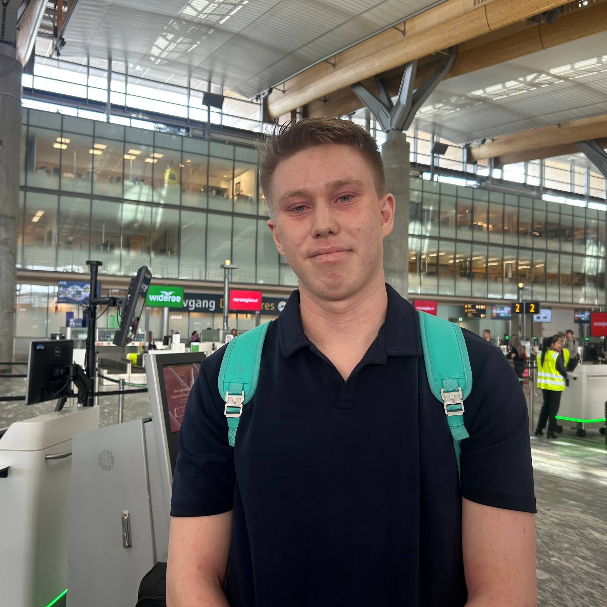 En mann som står med sekk på Gardermoen. 