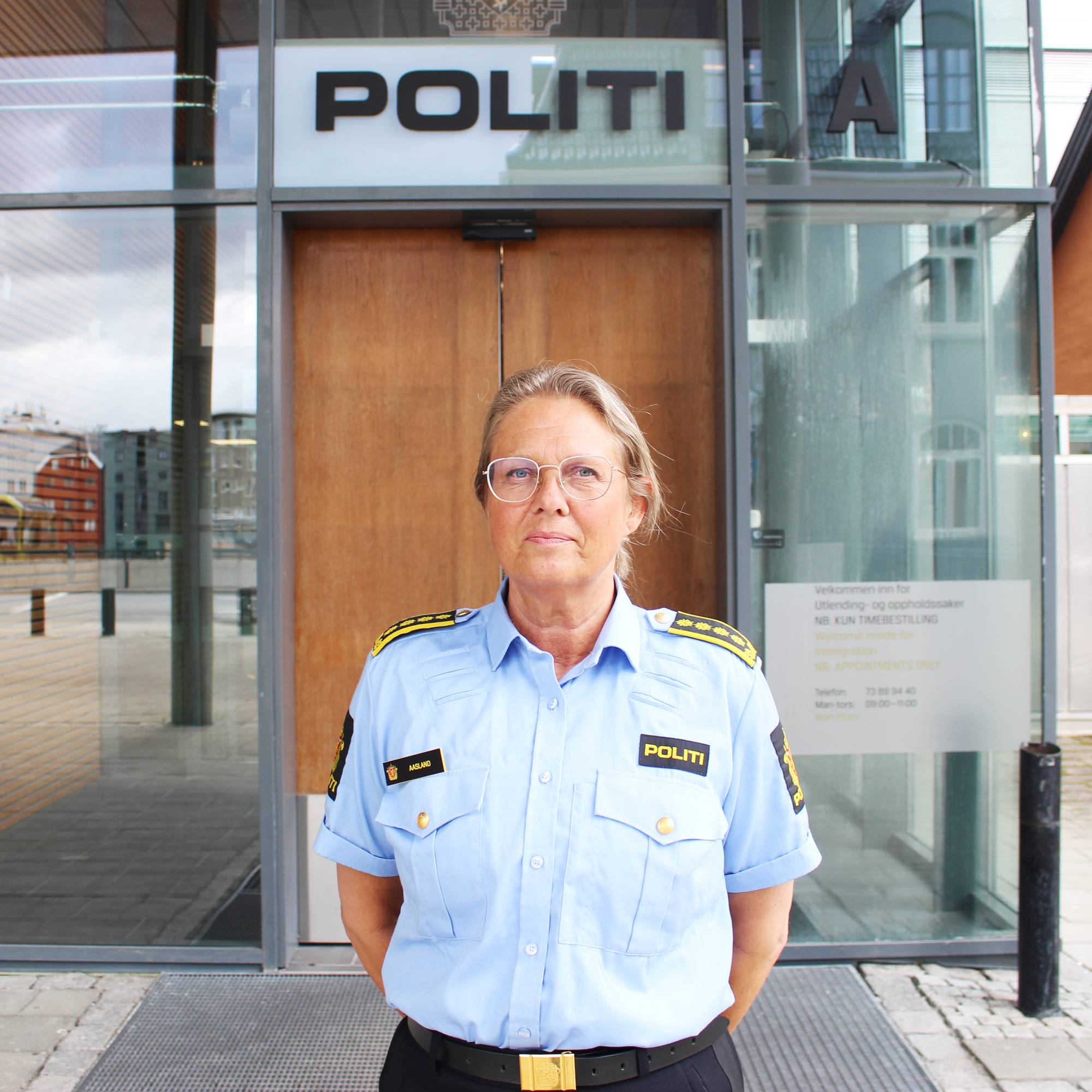 Påtaleleder Eli Trondvold Aasland står foran inngangen til politistasjonen i Trondheim. Over døren står det "Politi"