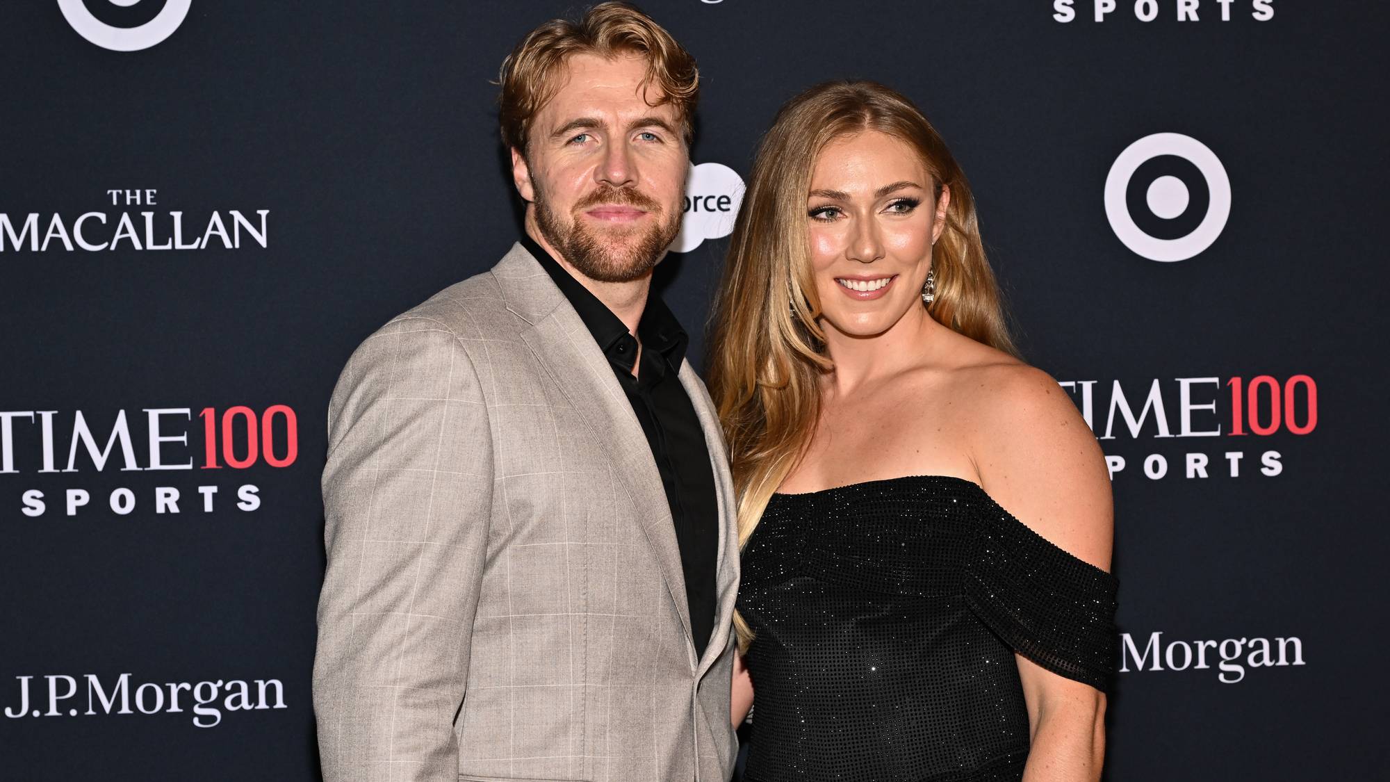 Aleksander Aamodt Kilde og Mikaela Shiffrin poserer sammen på en rød løper foran en logo-vegg. (Bildebeskrivelsen er laget av en KI-tjeneste)