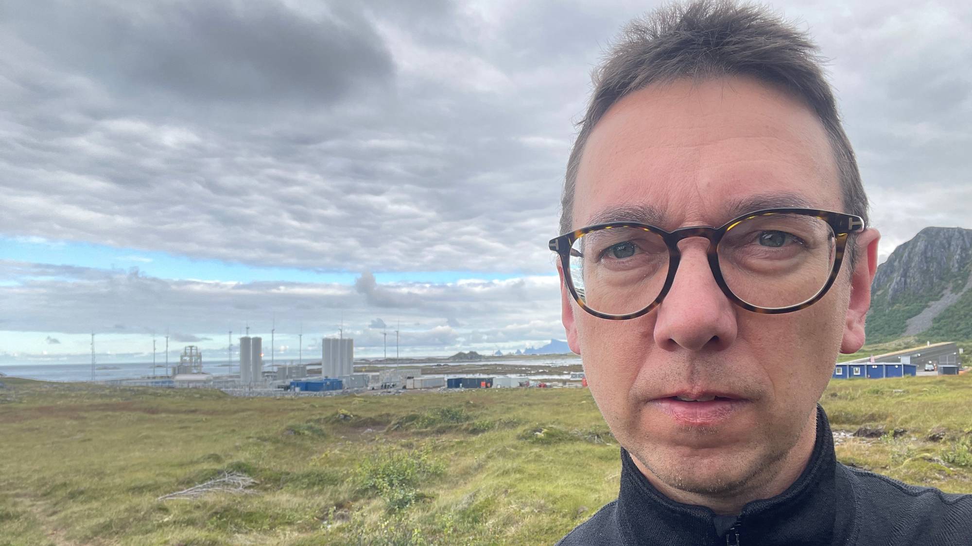 En mann med briller ser i kamera fra nært hold. 