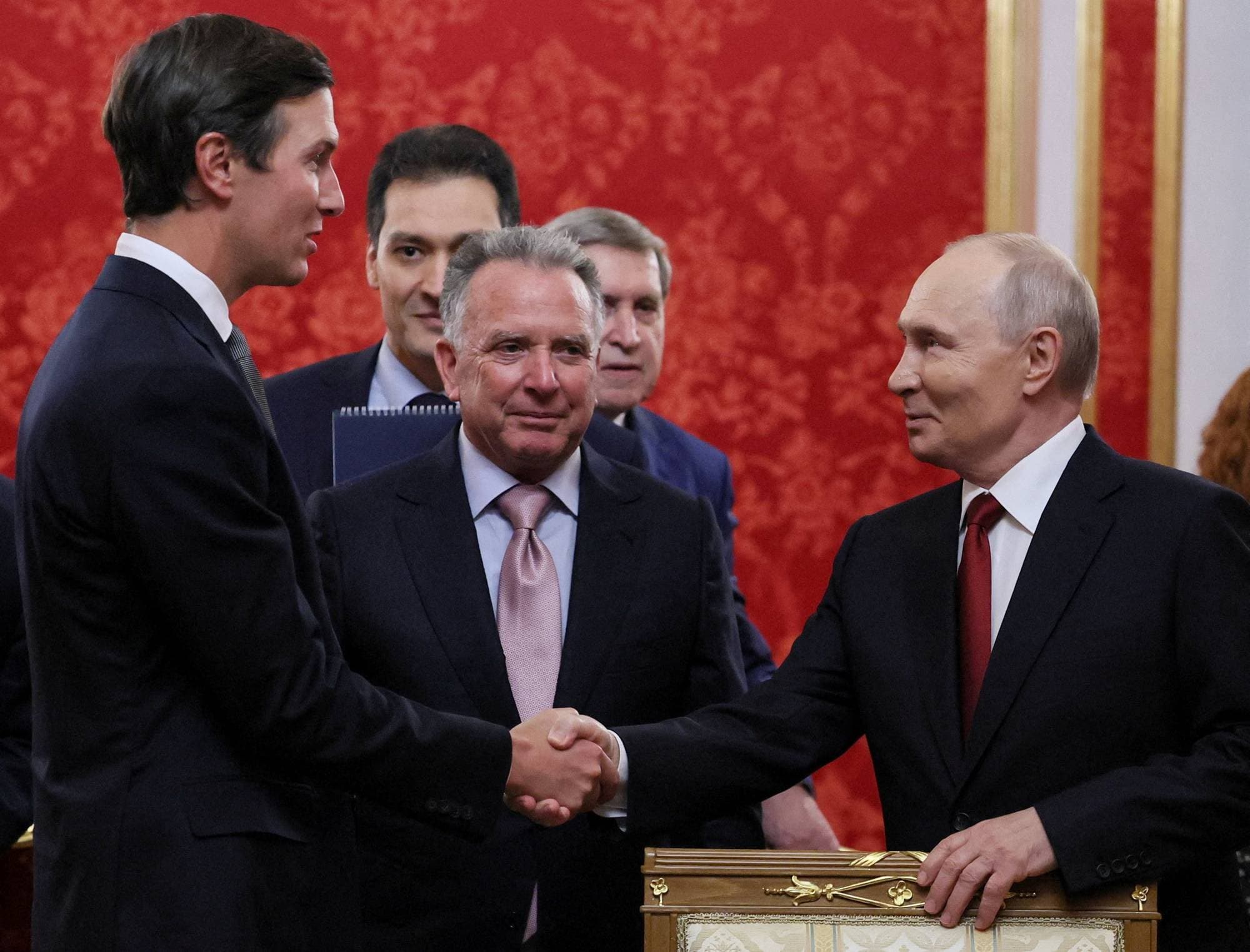 Jared Kushner håndhilser på Vladimir Putin foran en rød vegg. Andre menn står i bakgrunnen. (Bildebeskrivelsen er laget av en KI-tjeneste)