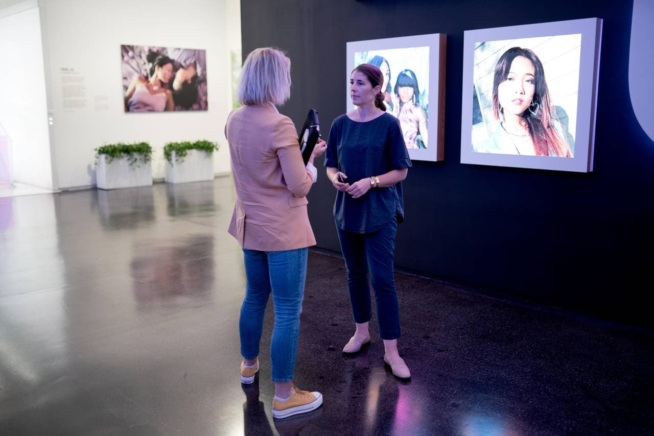 Journalist Annemarte Moland og Karina Newton er i Instagrams lokaler, og står foran noen skjermer som viser bilder av ulike personer.