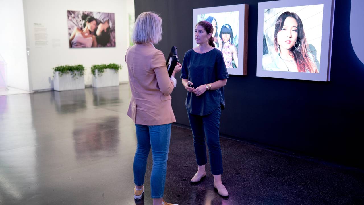 Journalist Annemarte Moland og Karina Newton er i Instagrams lokaler, og står foran noen skjermer som viser bilder av ulike personer.