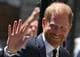 JUSTIN TALLIS / AFP,NTB Prins Harry smiler og vinker til folkemengden. Han er kledd i en mørk dress. (Bildebeskrivelsen er laget av en KI-tjeneste)