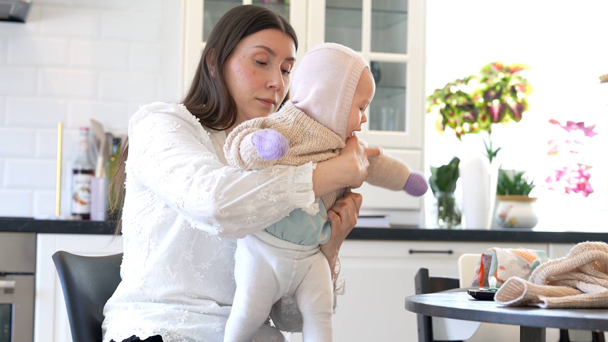 Susanne tar på klær til babyen slik at den er klar til å sove ute