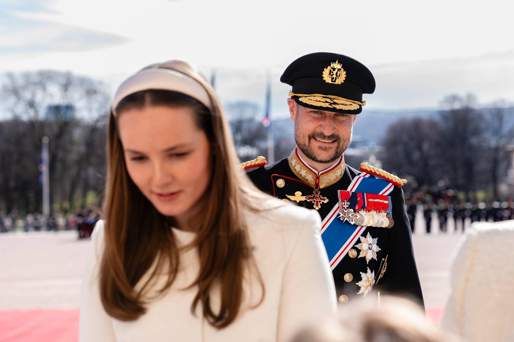 Kronprins Haakon står bak mens prinsesse Ingrid Alexandra snakker med skolebarn utenfor Slottet under statsbesøket fra Island