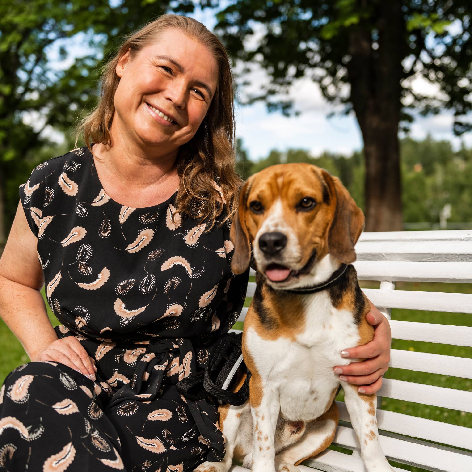 En person som sitter på en benk med en hund (Bildebeskrivelsen er laget av en KI-tjeneste)