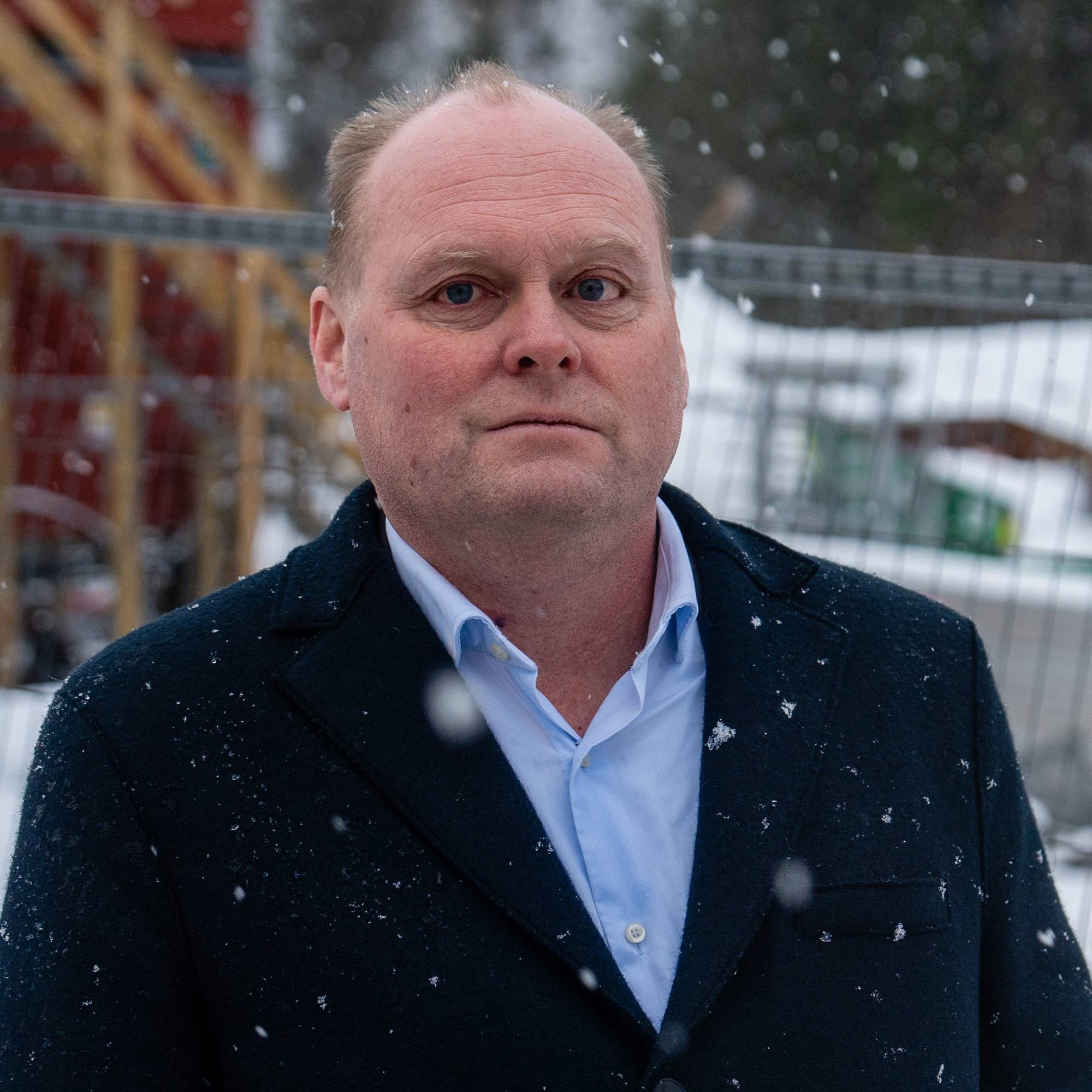 en mann står utenfor et stilas i snøen