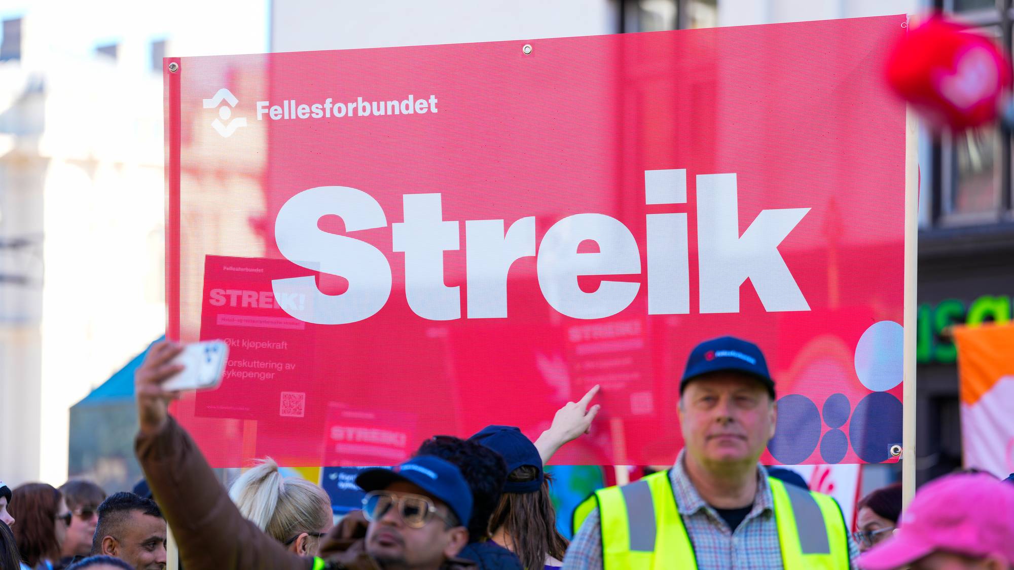 Folkefor­bundet streike-skilt med stor tekst «Streik!». Flere personer med gule vester er synlige, noen tar bilde med mobil. (Bildebeskrivelsen er laget av en KI-tjeneste)