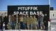 Jim Watson / Pool AFP,NTB En gruppe mennesker står foran et skilt merket Pituffik Space Base i et snødekket landskap. (Bildebeskrivelsen er laget av en KI-tjeneste)