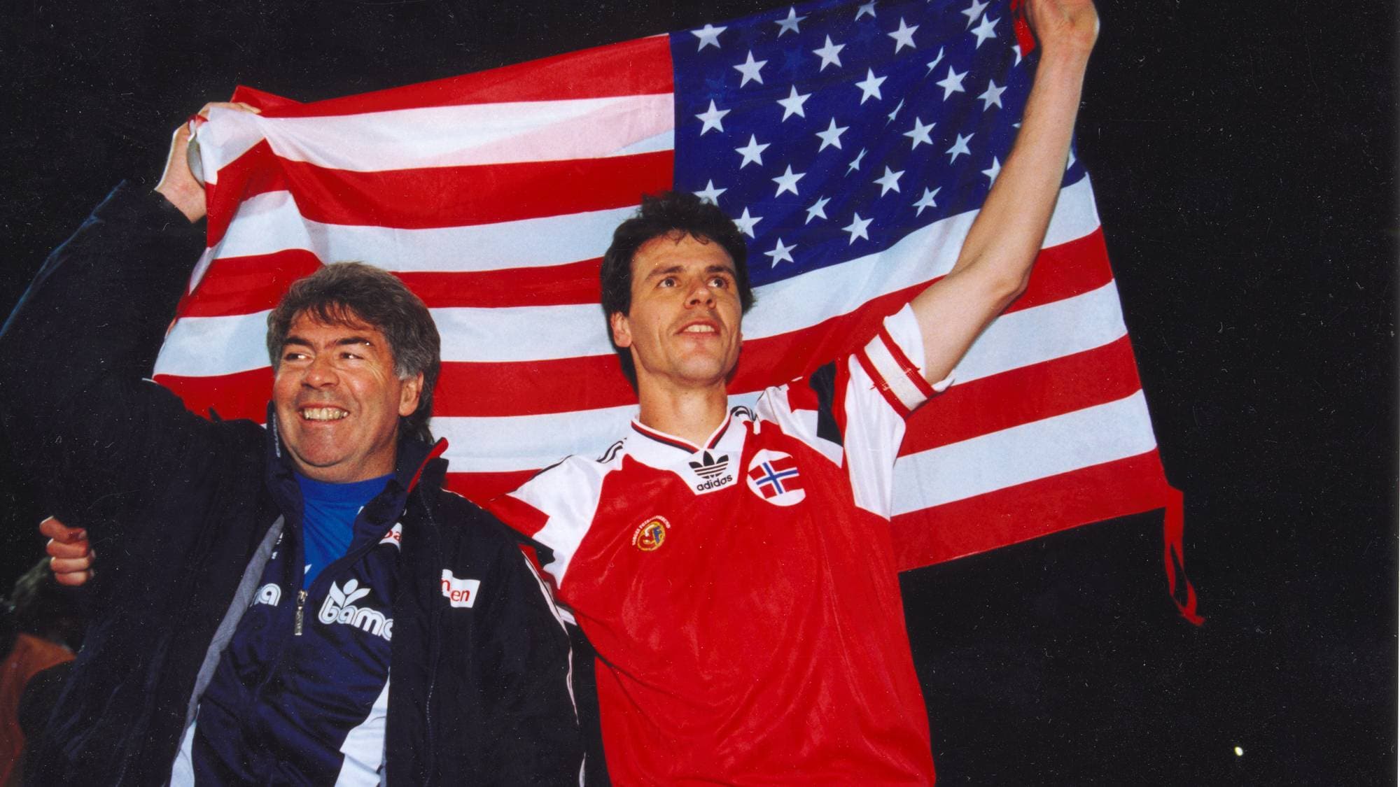 POZNAN POLEN 19931013 Fotball, Landskamp og VM kvalifisering Polen - Norge (0-3). Rune Bratseth (th) jubler sammen med landslagstrener Egil "Drillo" Olsen foran et amerikansk flagg etter seieren. (Fotball-VM 1994 - USA) FL 31384-12
Foto: Bjørn Sigurdsøn