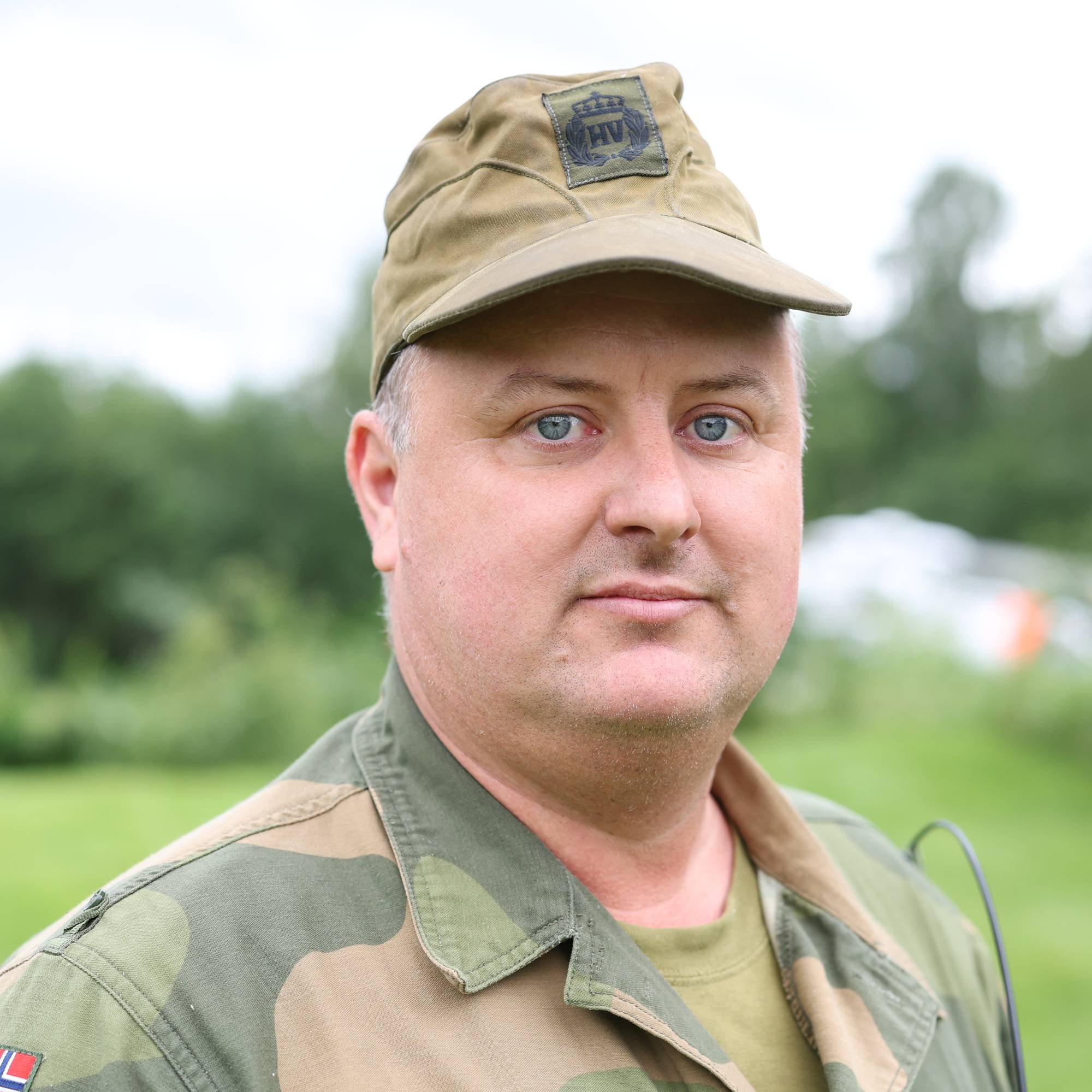 Portrett av en mann i uniform fra Heimevernet utendørs i grønne omgivelser. (Bildebeskrivelsen er laget av en KI-tjeneste)