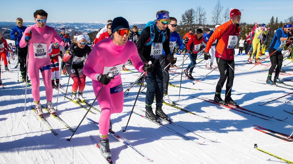 Et stort antall skiløpere står klare ved startstreken i en konkurranse. Flere av deltakerne er iført fargerike dresser, inkludert en gruppe i knallrosa. Solen skinner og det er snødekte fjell i bakgrunnen. FOTO: Håkon Mosvold Larsen/NTB,NTB