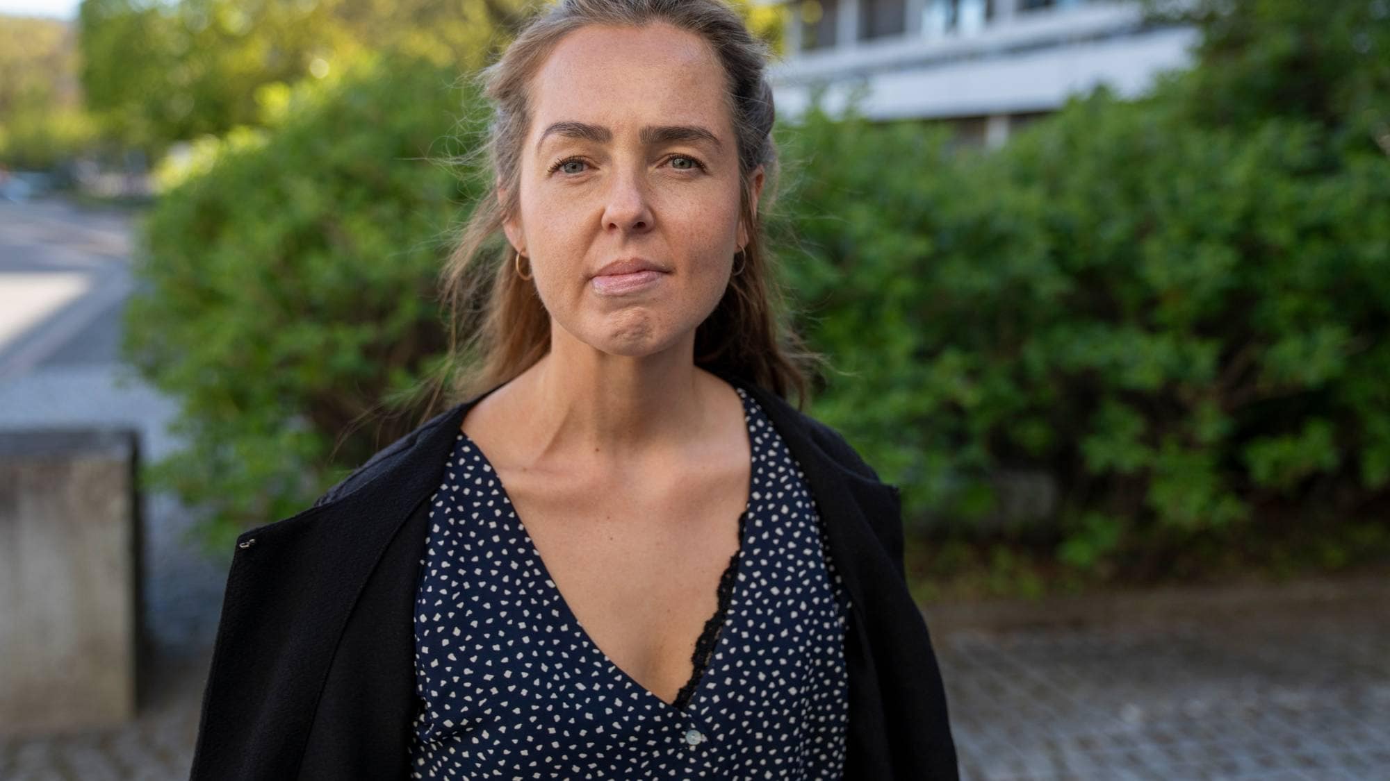 En kvinne står utenfor (Bildebeskrivelsen er laget av en KI-tjeneste)