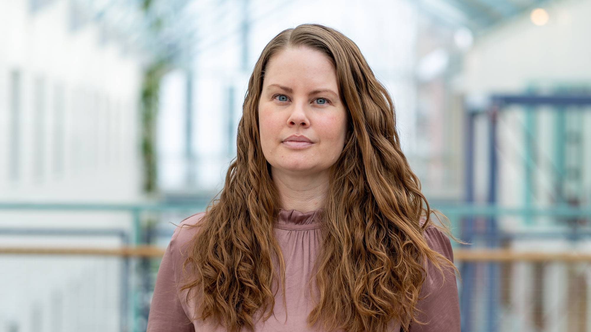 Kvinne med langt hår ser i kamera