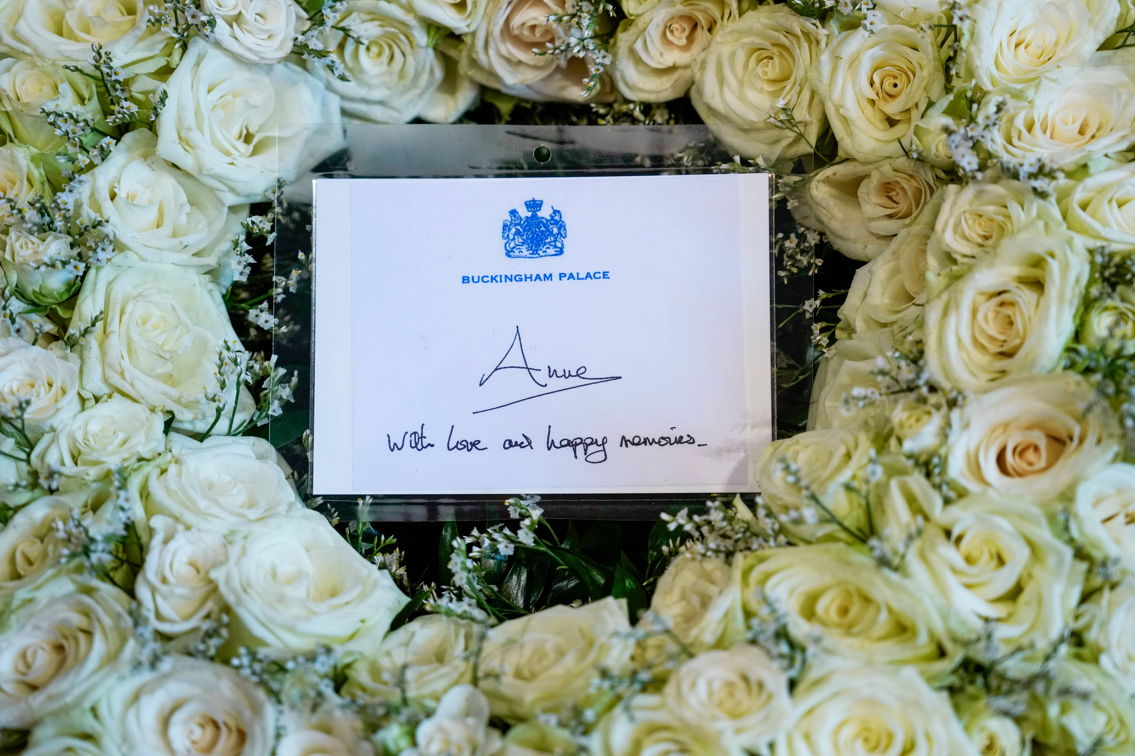 hvite roser med kort fra Buckingham palace. På kortet står det "with love and happy memories"