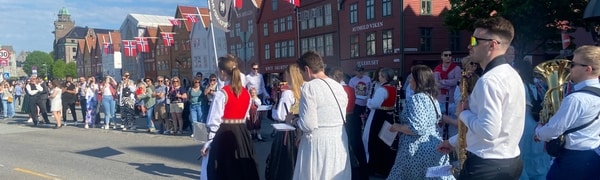 en gruppe mennesker som går i en gate med en folkemengde som ser på