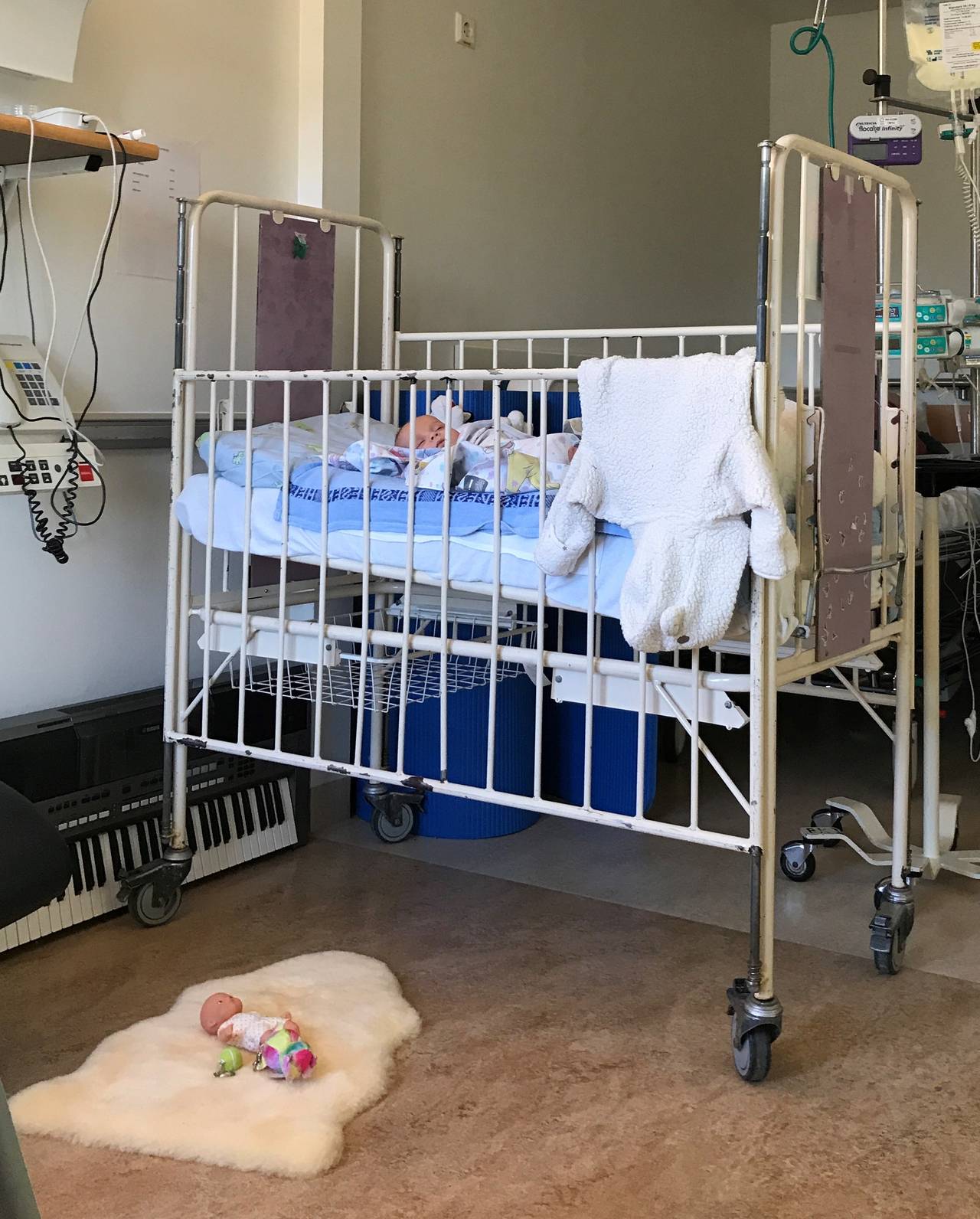 Sonia Victoria nel suo letto d'ospedale.  La bambola sul pavimento è l'unica cosa che indica che la stanza appartiene a un bambino.