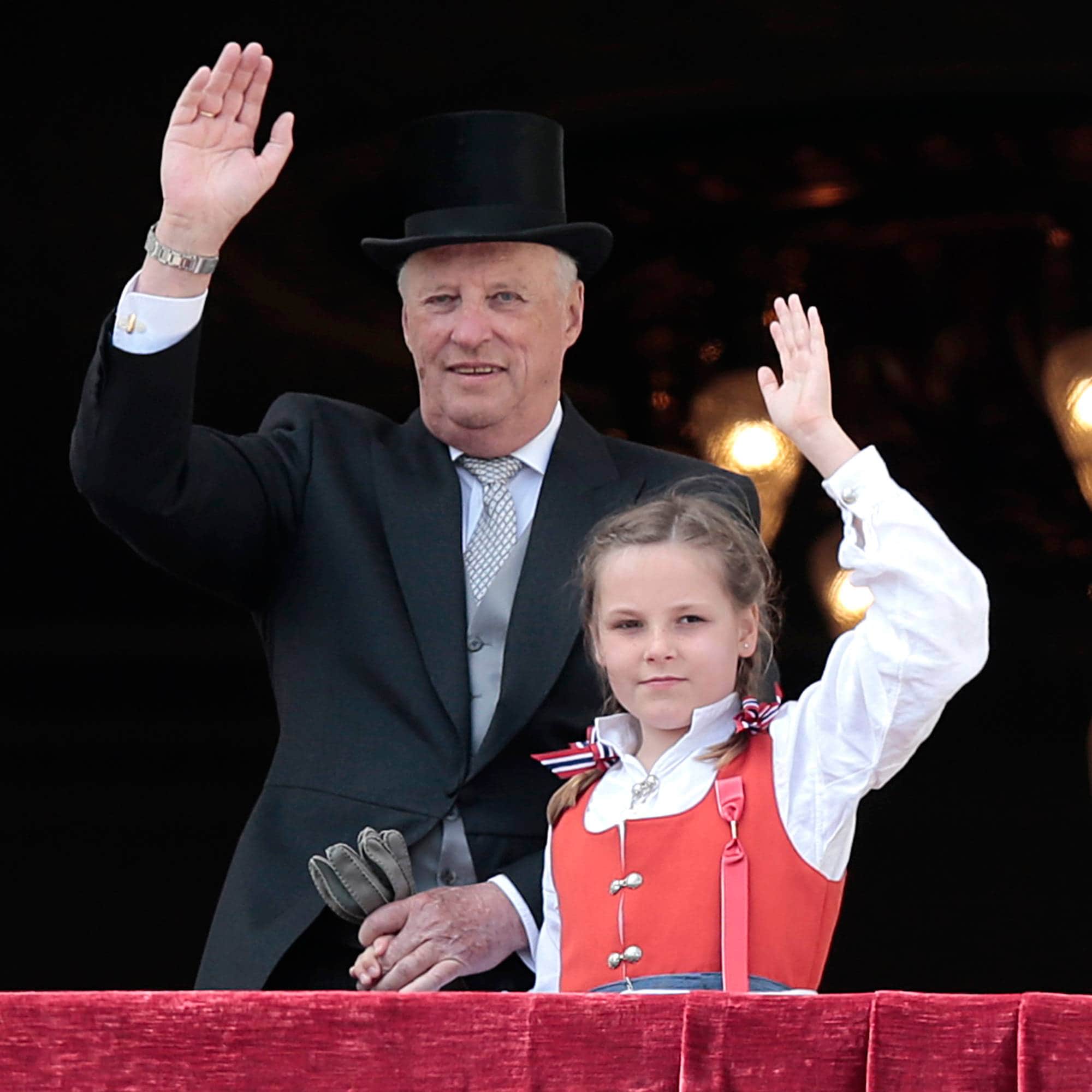 Kong Harald holder prinsesse Ingrid Alexandra i hånden og vinker på 17. mai