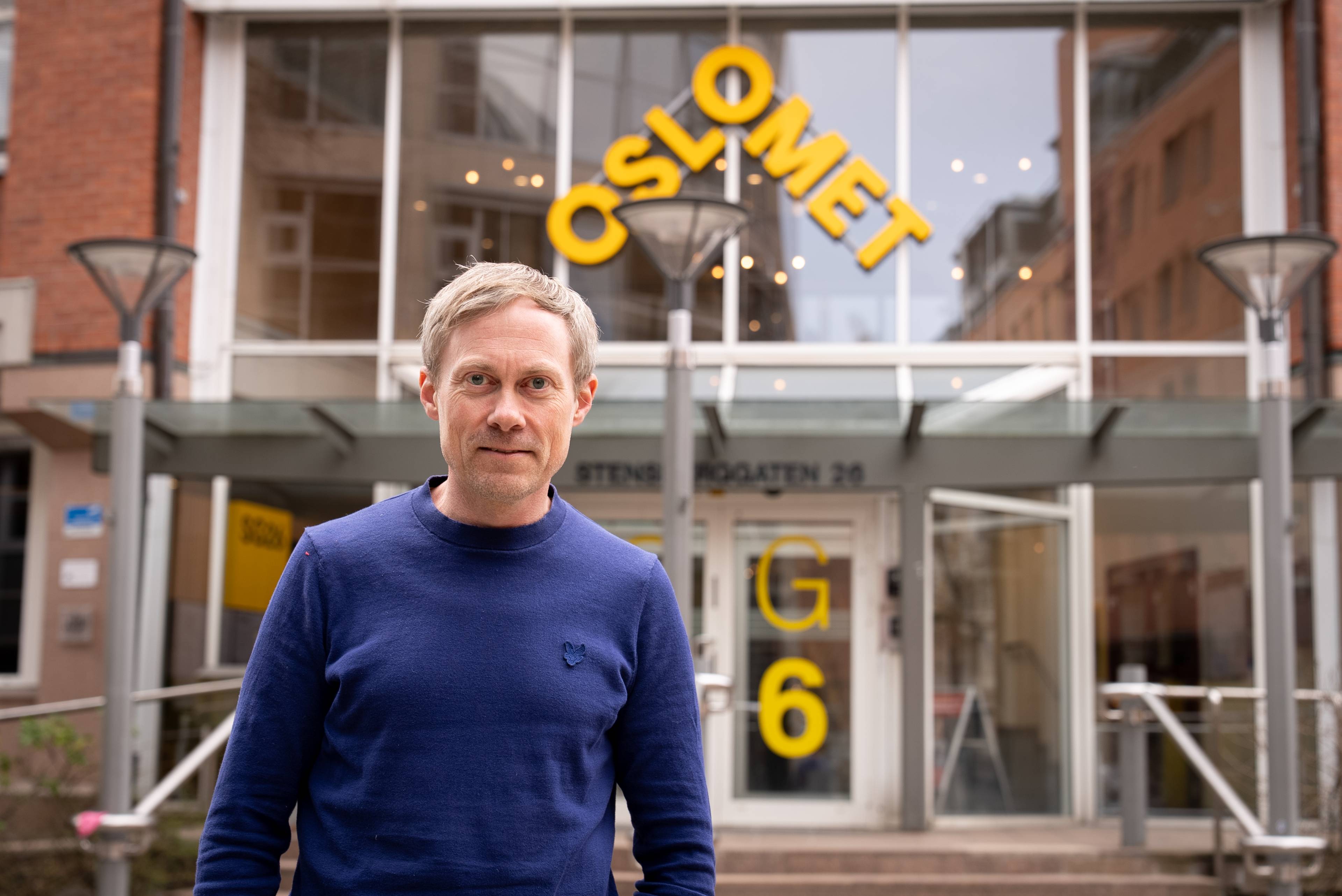 portrettbilde av forsker Lars Roar Frøyland foran hovedinngangen til Oslo Met.