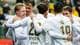Tor Erik Schrøder / NTB En gruppe fotballspillere i hvite drakter omfavner hverandre. Spillerne smiler og virker glade. Tilskuere i bakgrunnen kan sees på tribunen. Bildet er tatt utendørs på en idrettsplass. (Bildebeskrivelsen er laget av en KI-tjeneste)