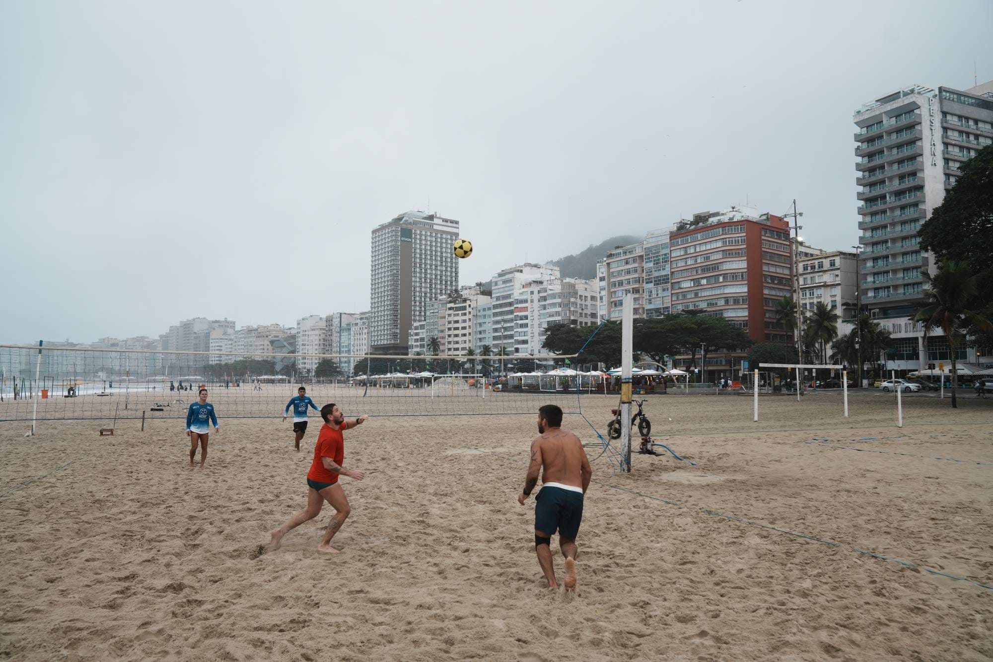 Personer spiller sandvolleyball på en strand i Brasil. (Bildebeskrivelsen er laget av en KI-tjeneste)