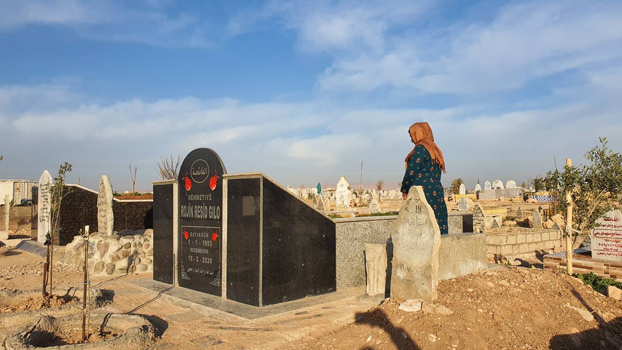 En kvinne i Syria står ved graven til en kvinne født i 1993, død 2020.