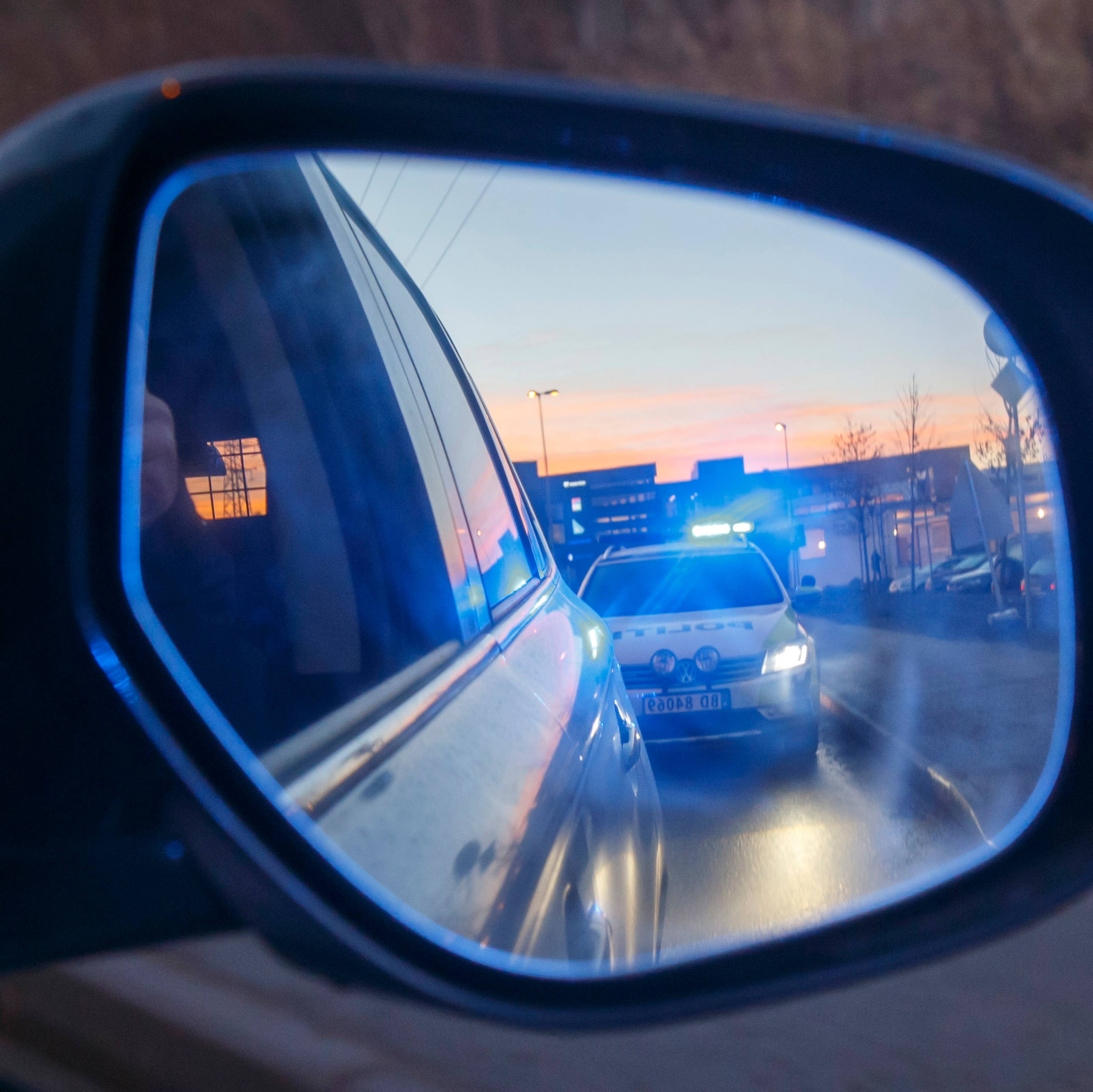 REKORDÅR: Politiet har aldri anmeldt så mange sjåfører for ruskjøring som de gjorde i 2020. SKI  20161213.Politiet i arbeid. En politibil med blålys sees i sidespeilet på en bil i fart. NB! Modellklarert til redaksjonell bruk. Foto: Heiko Junge / NTB