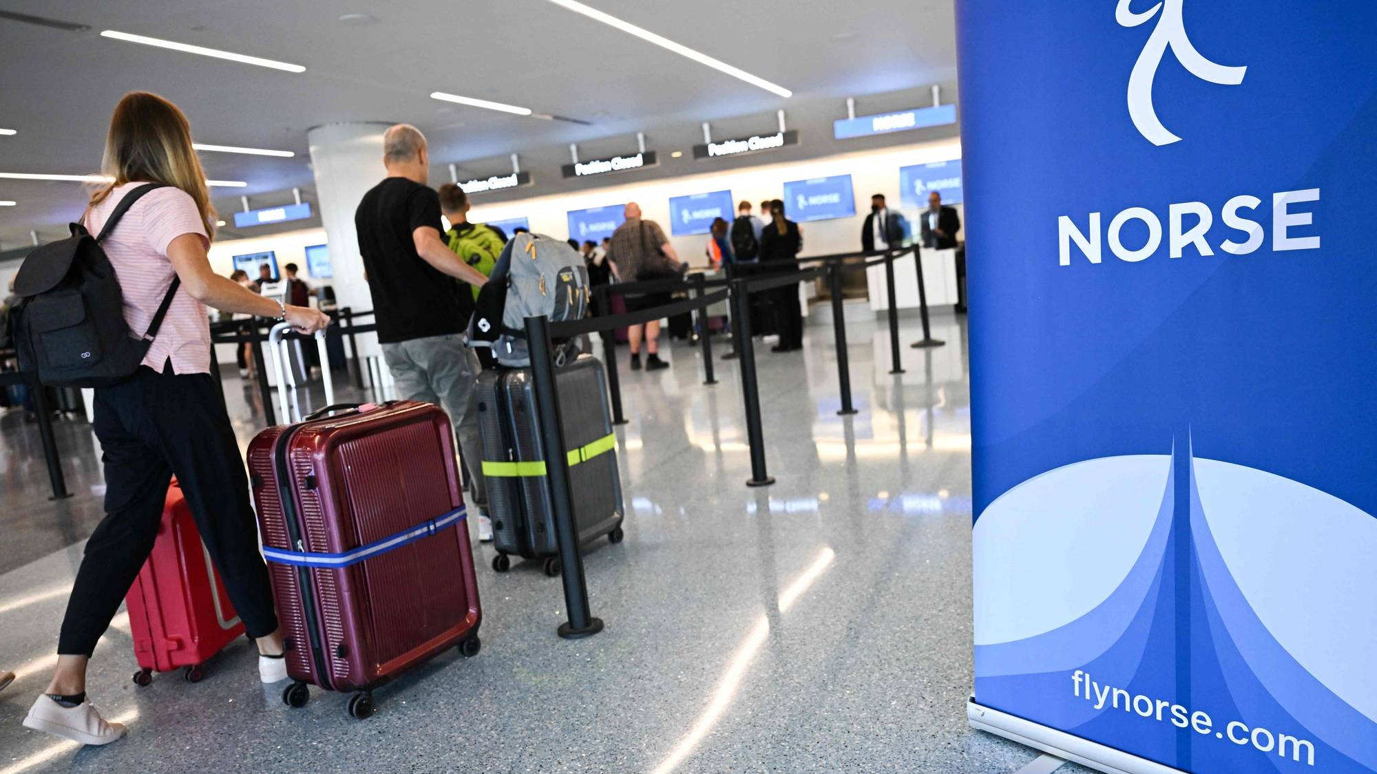 viser mennesker med kofferter på flyplass