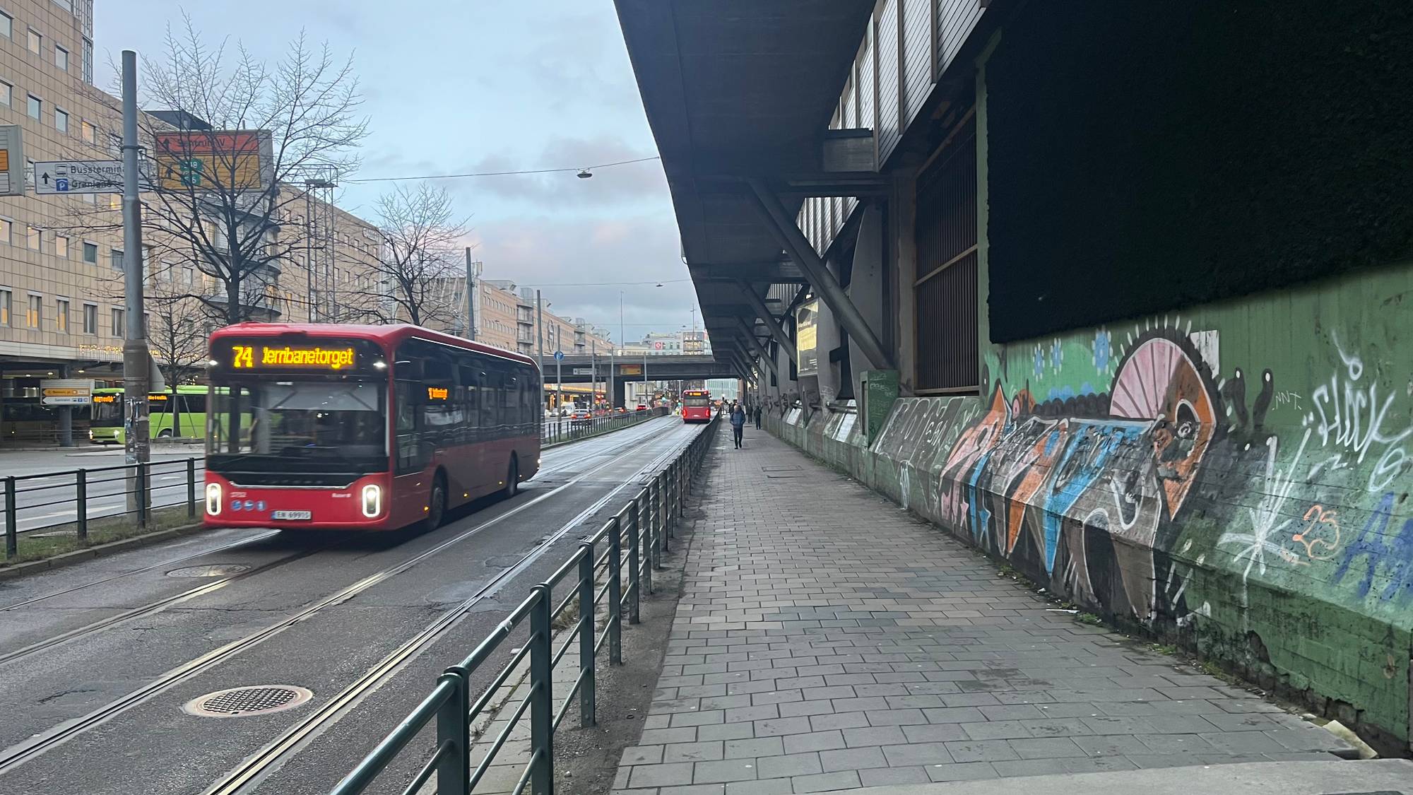 En buss som kjører nedover en gate (Bildebeskrivelsen er laget av en KI-tjeneste)