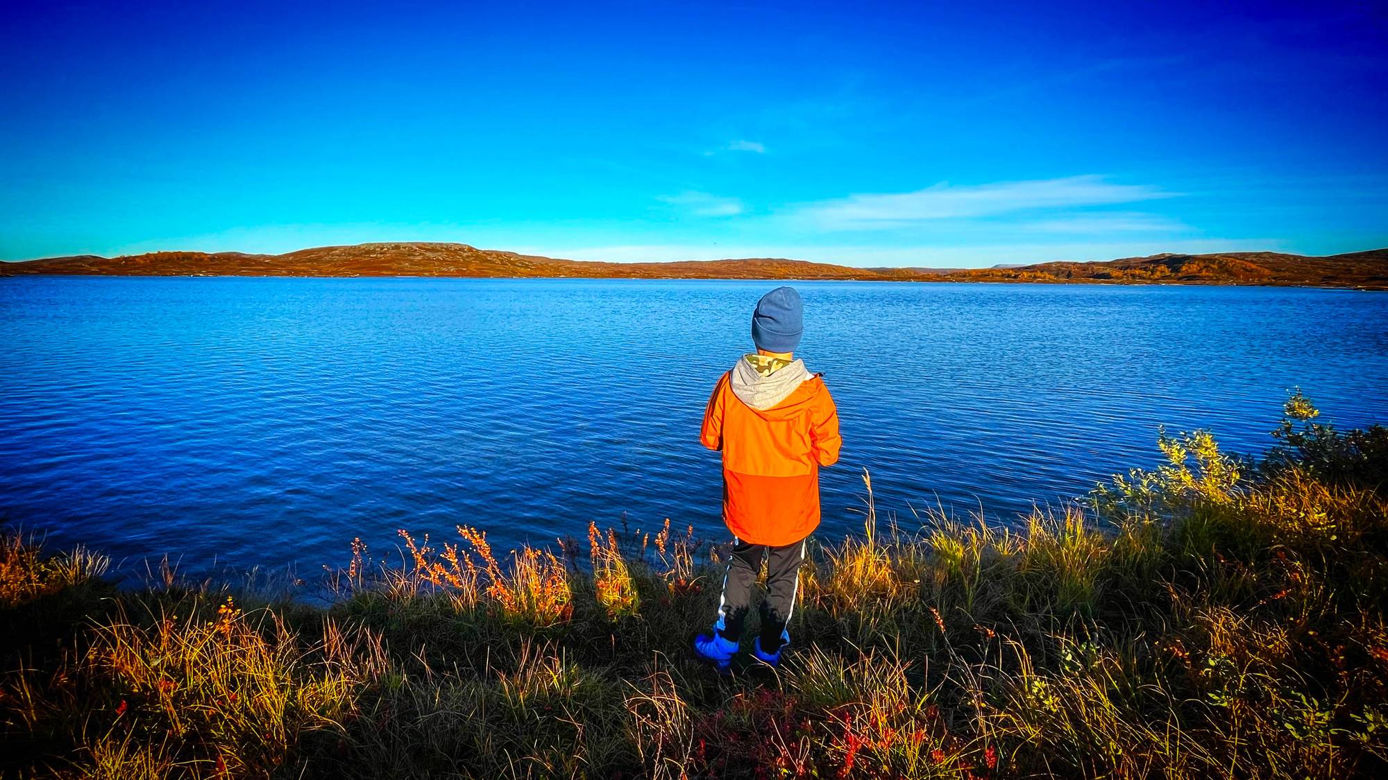 Gutt som fisker i et fjellvann