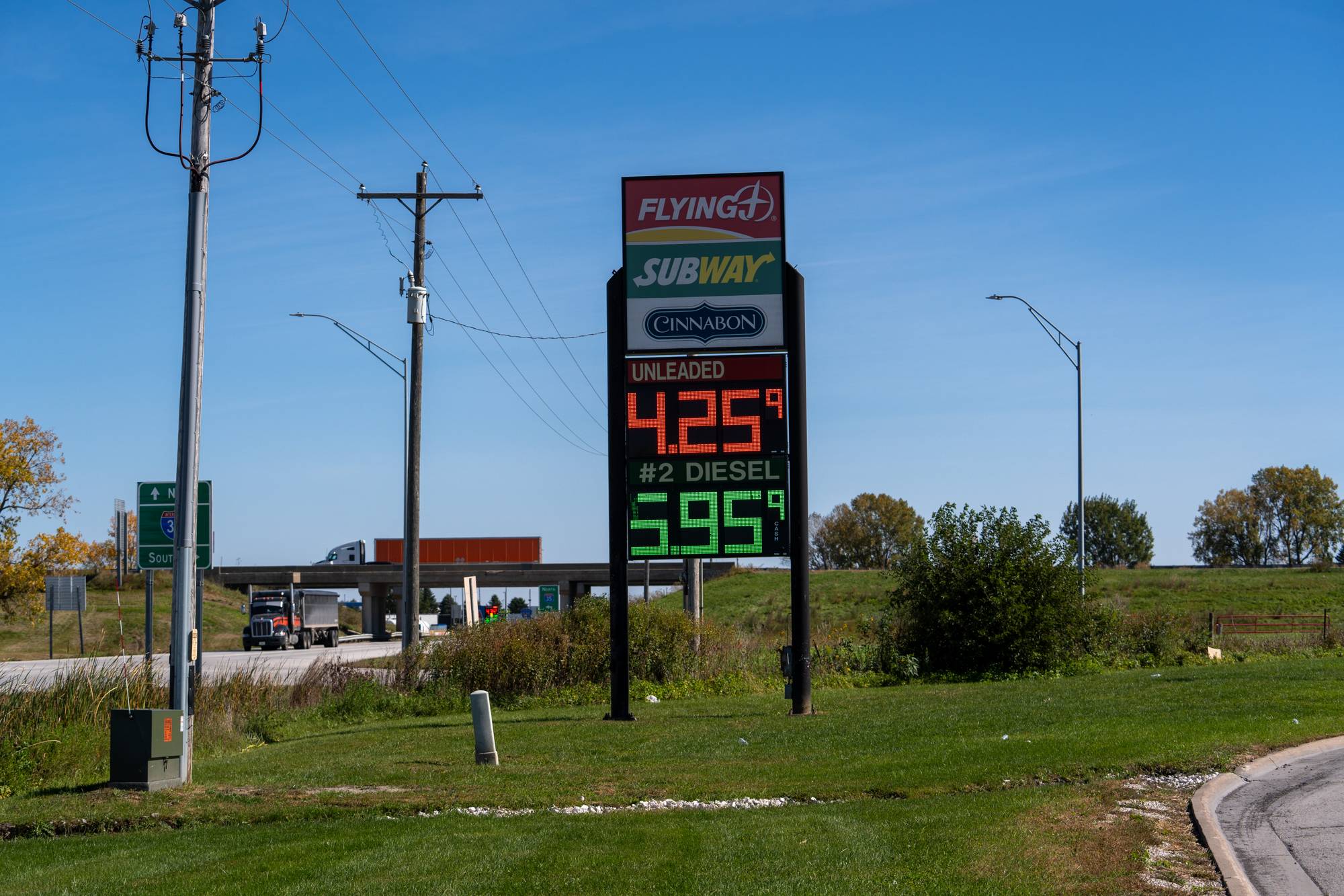 Skilt viser bensin- og dieselpriser ved en vei. Prisene er 4,25 dollar for bensin og 5,95 for diesel. (Bildebeskrivelsen er laget av en KI-tjeneste)