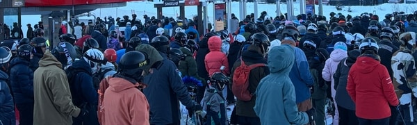 En gruppe mennesker samles utenfor en skihytte