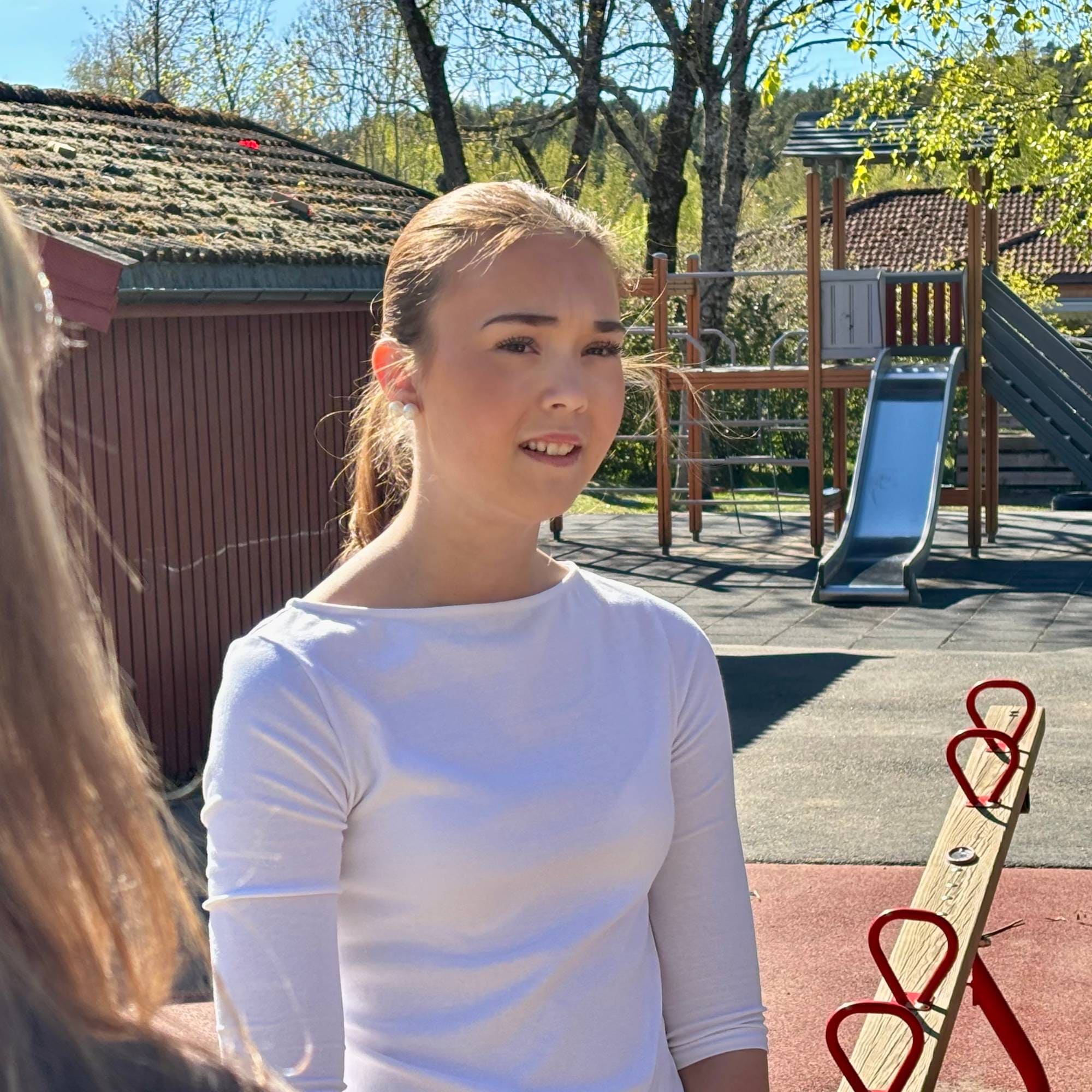 En ung person med lys topp og akesklie bak seg