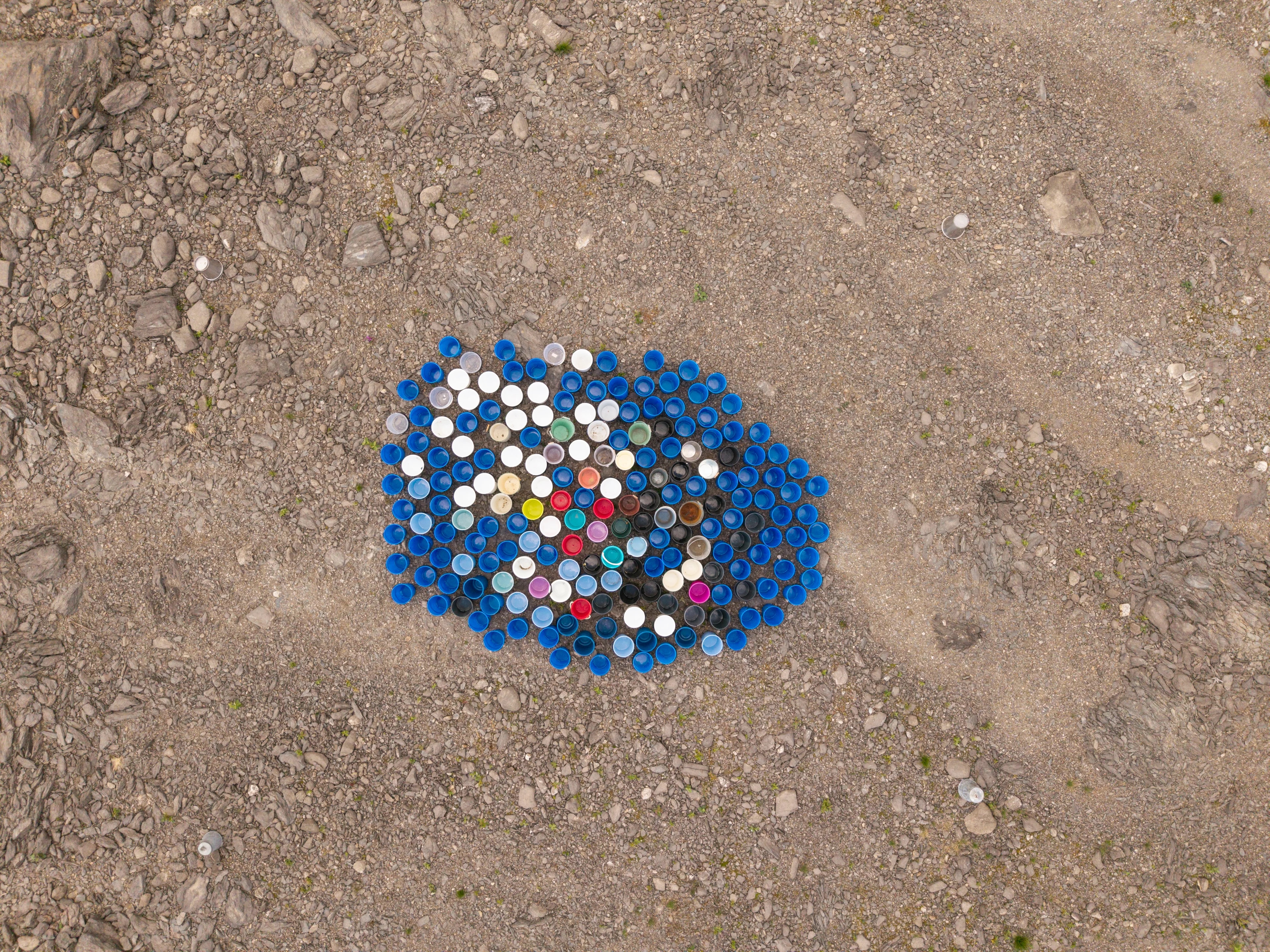 Dronefoto av 200 vaskebøtter som står i en tett klynge på bakken.