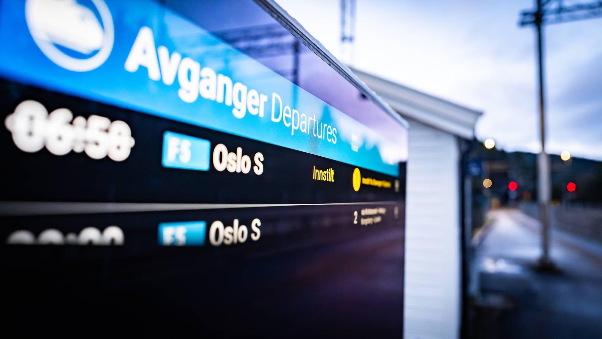 Togavgangstavle viser "Avganger Departures" og rutetider. Togene går til Oslo S. En av avgangene er innstilt. (Bildebeskrivelsen er laget av en KI-tjeneste)