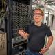 Leif Hallgeir Dalen / NRK Ung mann i svart t-skjorte står foran en rekke servere i et datarom. Vedkommende holder en hånd opp og forklarer noe. Omgivelsene inkluderer kabler og datamaskinuttak på veggene. I bakgrunnen er det flere servere.