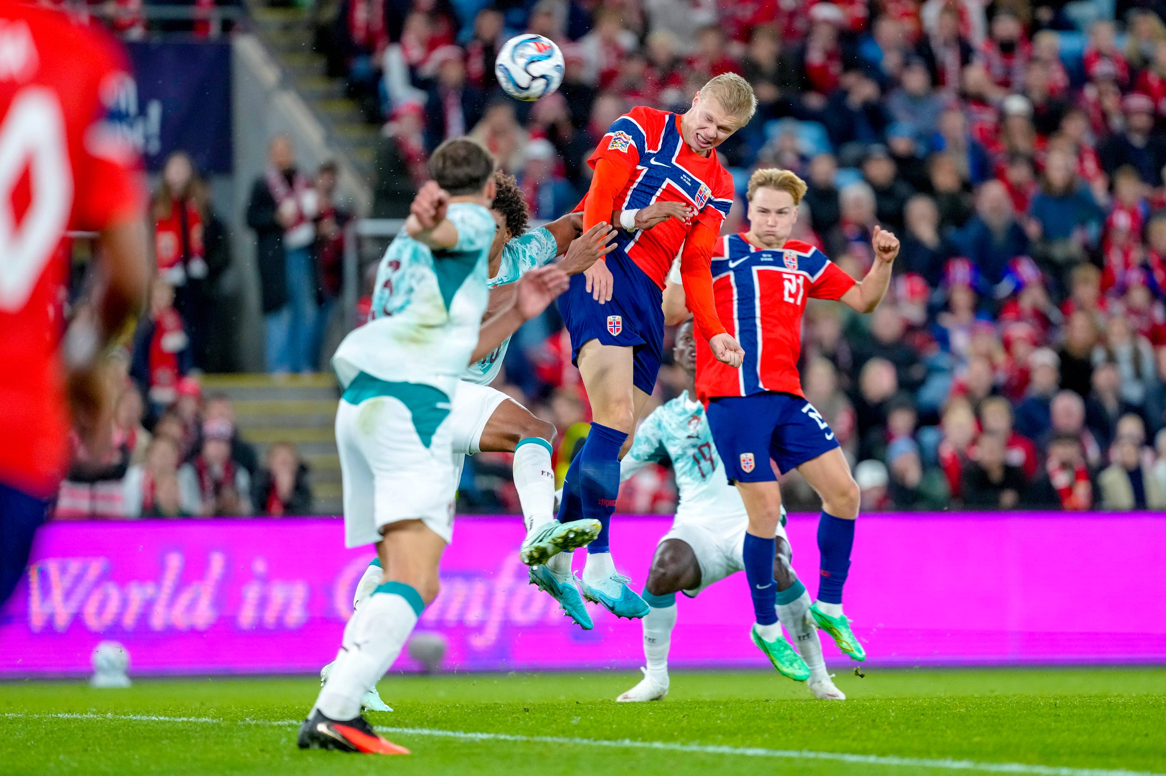 Erling Braut Haaland header ballen i en landskamp i fotball mellom Norge og en motstander. (Bildebeskrivelsen er laget av en KI-tjeneste)